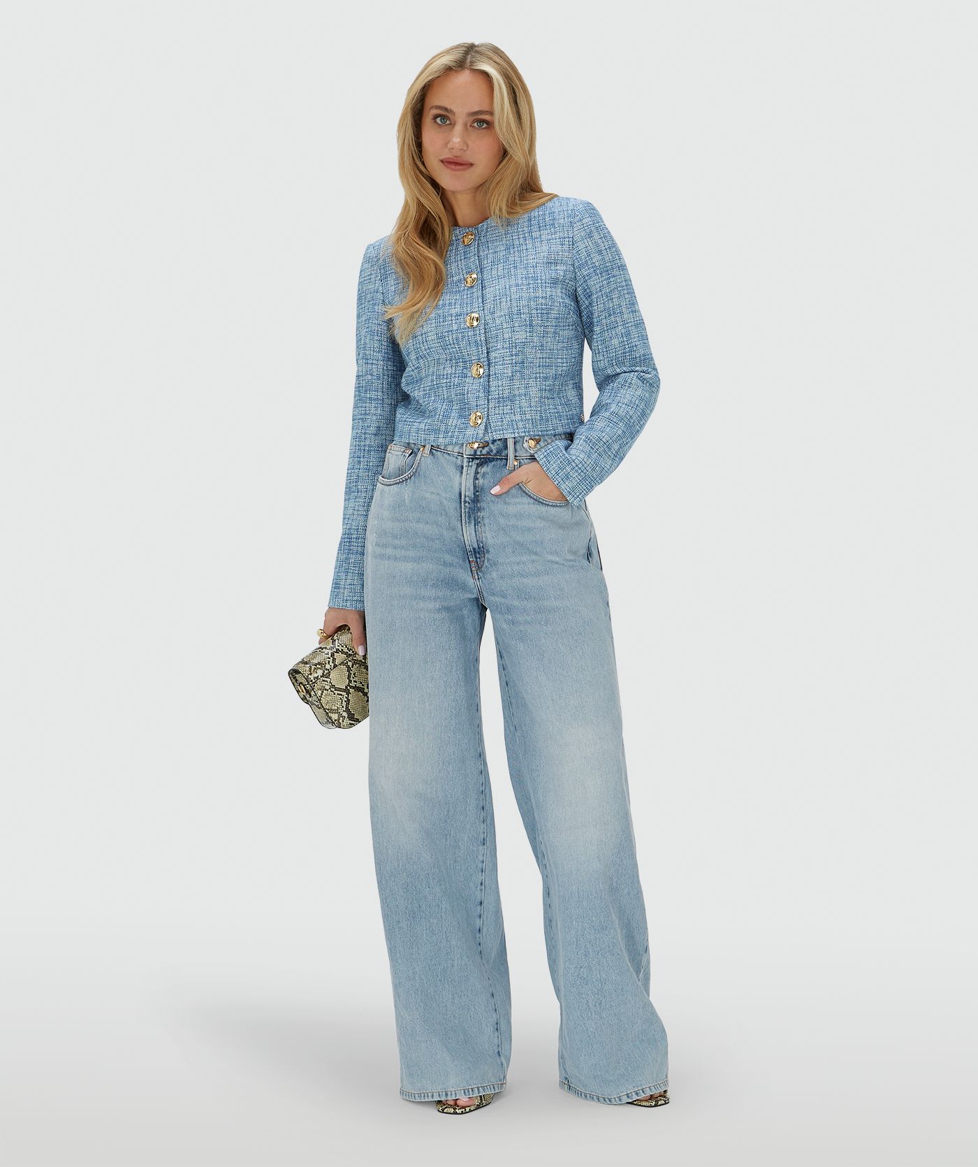 Model draagt een cropped blazer met lurex, uitgevoerd in de kleur Blue Bouclé