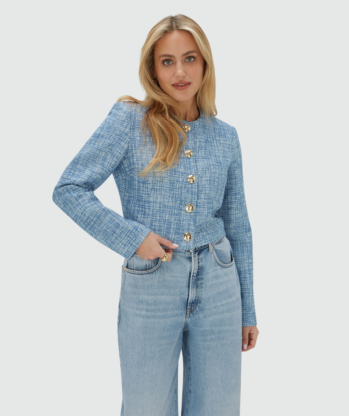 Model draagt een cropped blazer met lurex, uitgevoerd in de kleur Blue Bouclé