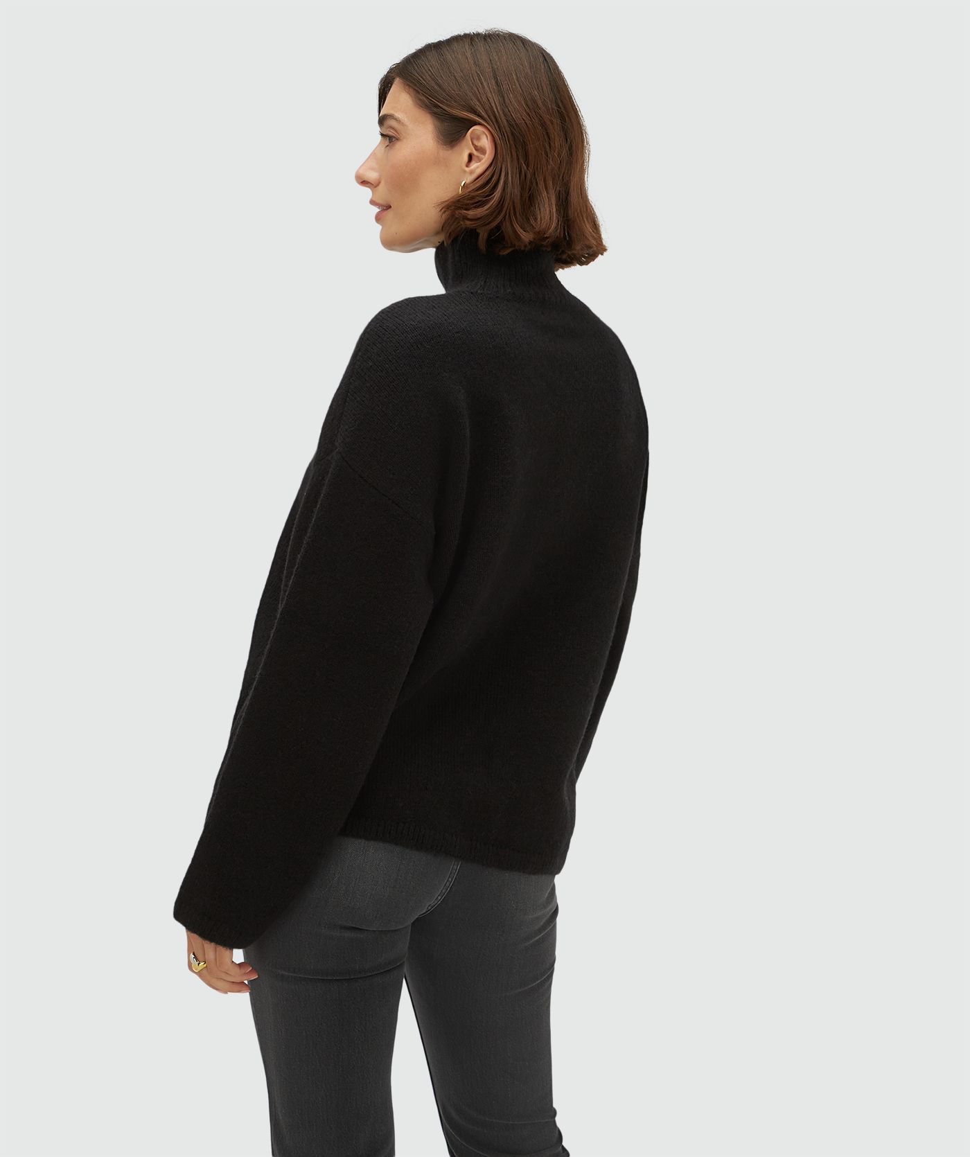 Achteraanzicht van een model in en oversized coltrui met wol 
