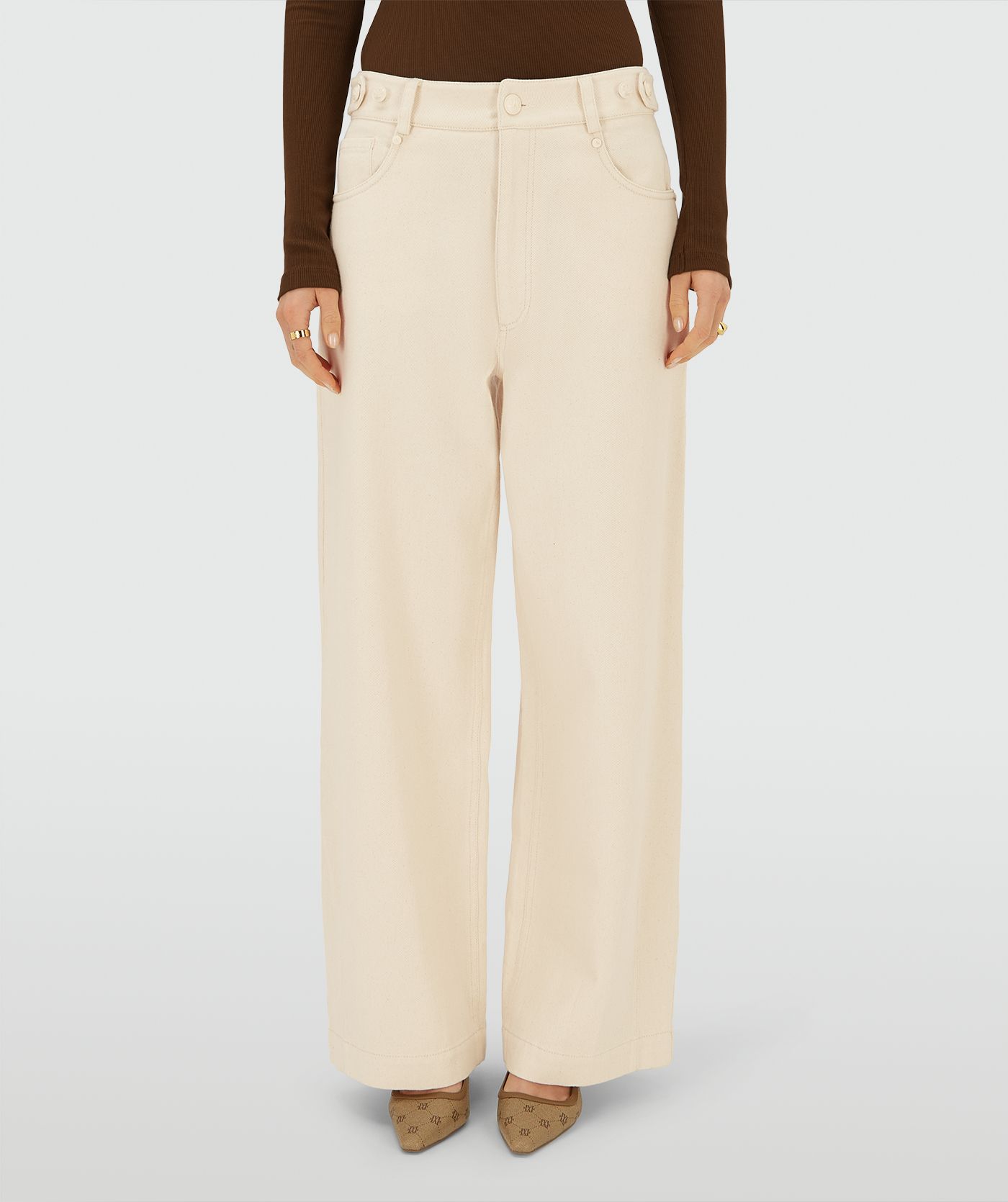 Model draagt een Ecru high-waist, wide-leg broek met steekzakken