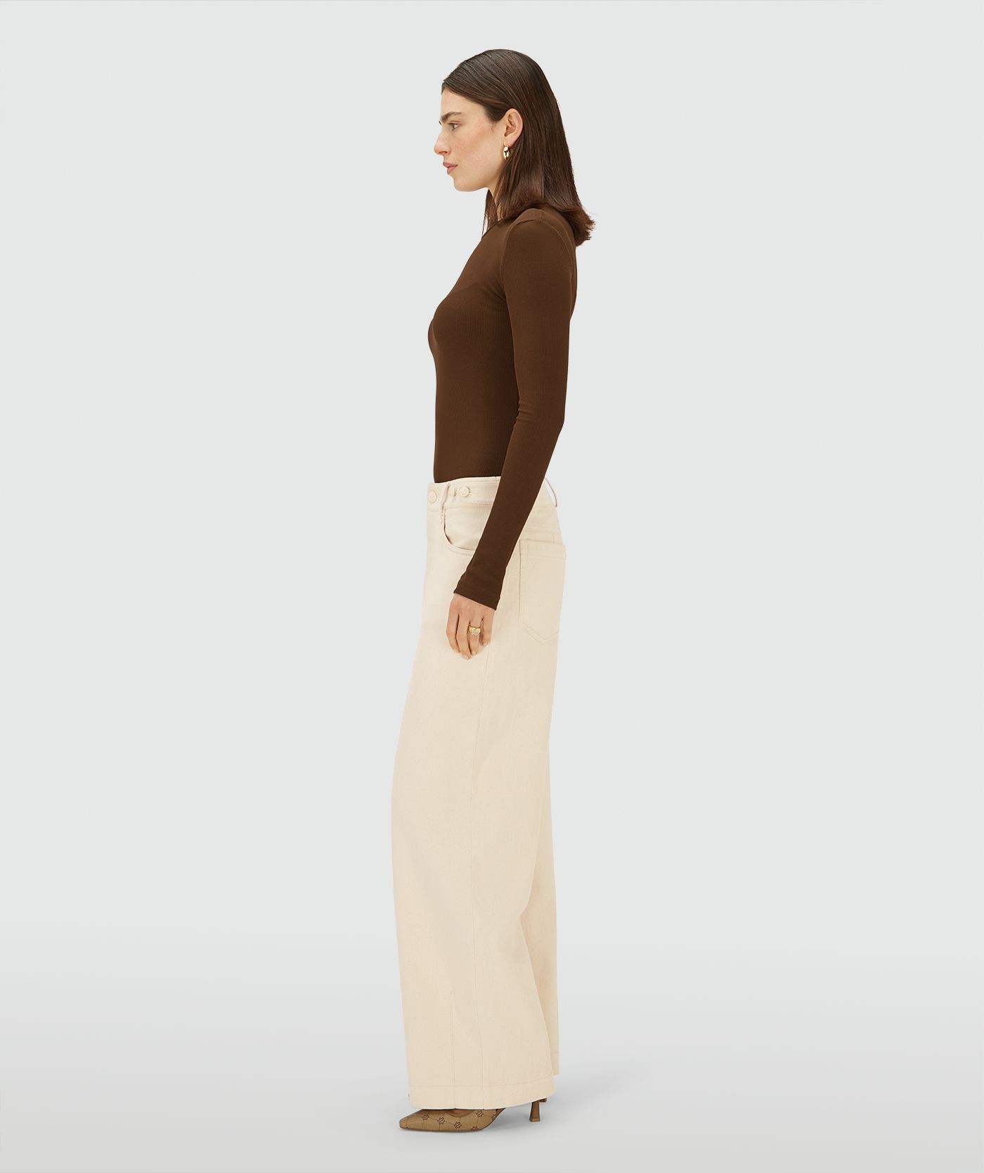 Zijaanzicht van een model in een Ecru high-waist, wide-leg broek met steekzakken