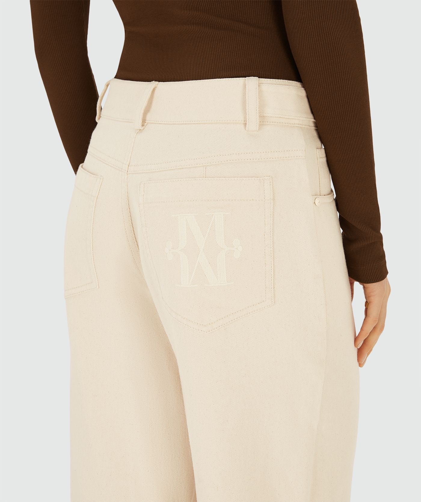 Achteraanzicht van een model in Ecru high-waist, wide-leg broek met steekzakken en JV- monogram achterop de zak