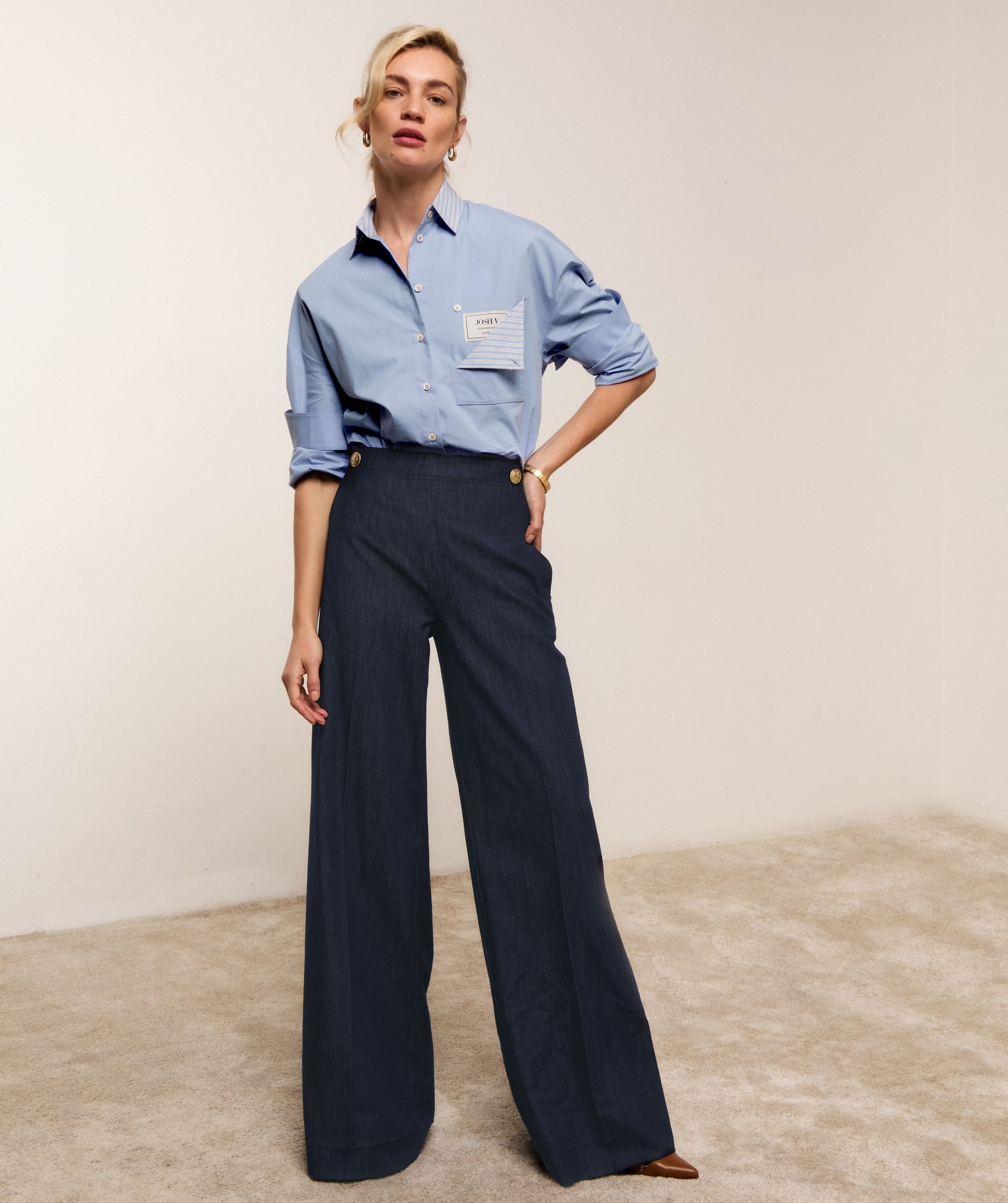 Model draagt een lichtblauwe oversized blouse met een opengevouwen borstzak waar een JOSH V-label zichtbaar is.
