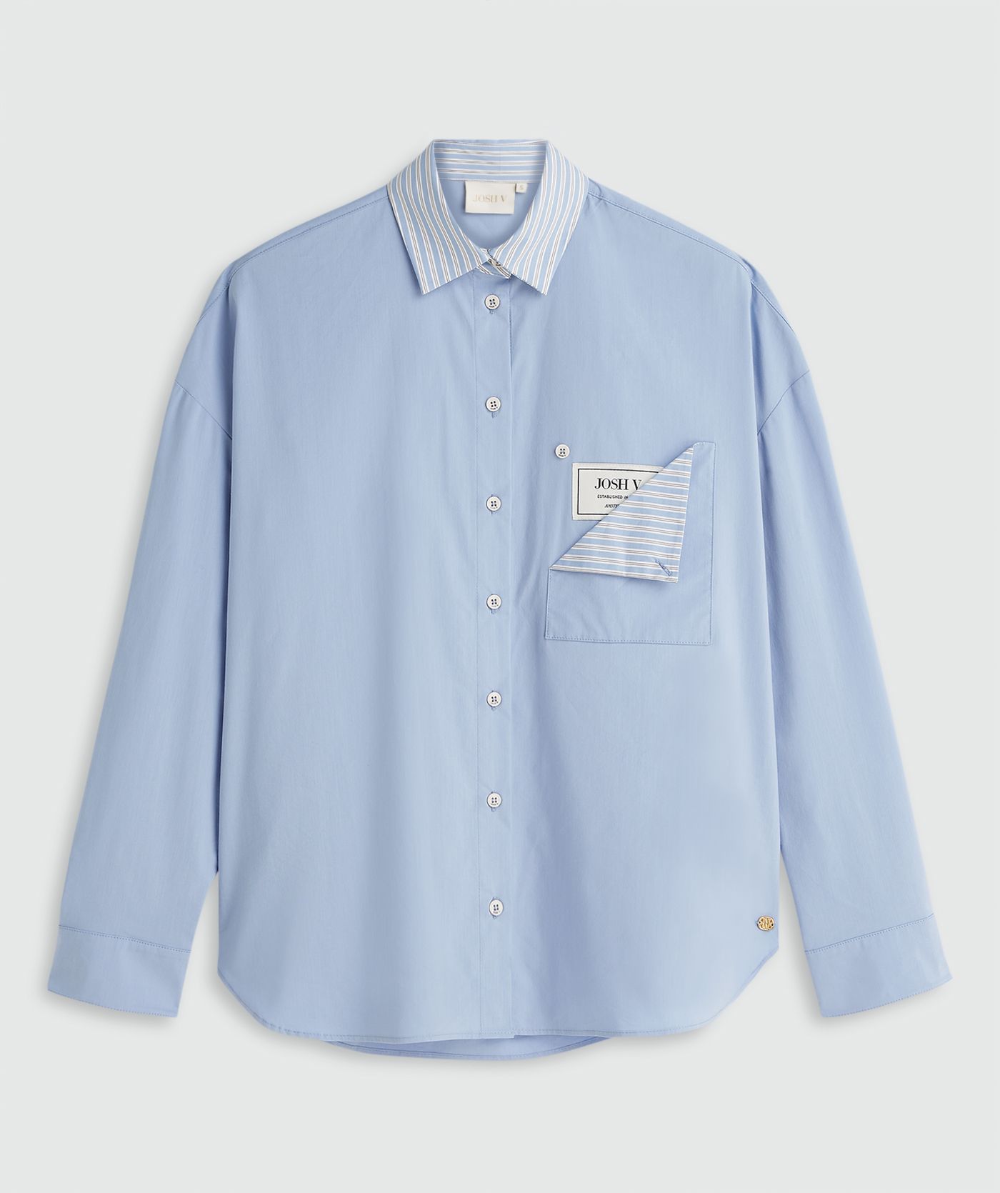 Lichtblauwe blouse zonder model, weergegeven op een lichtgrijze achtergrond.