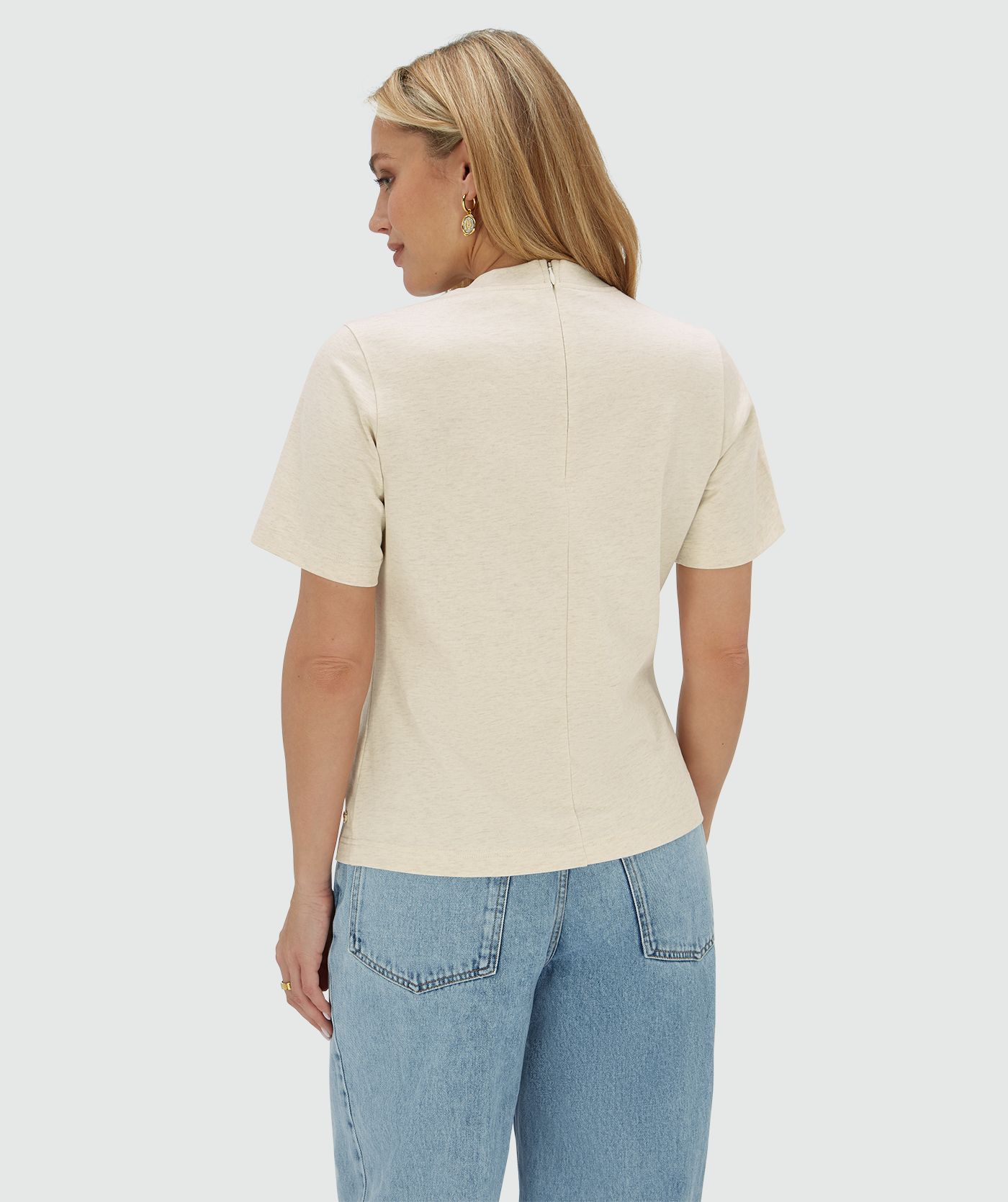 Model draagt een regular fit short sleeve T-shirt met strass rondom de neklijn waarin de ritssluiting op de rug te zien is