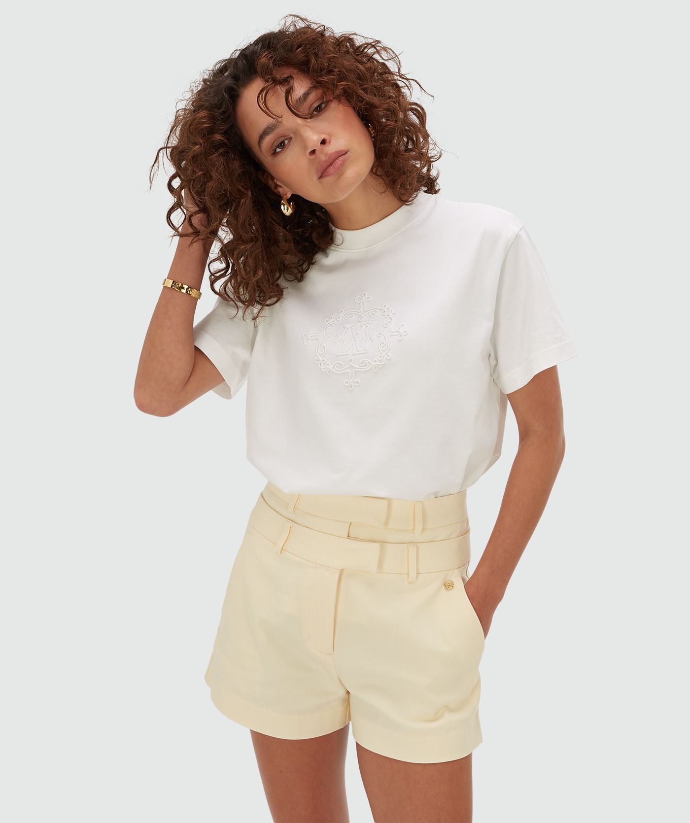 Model draagt een oversized T-shirt met logo in de kleur off white met geborduurd JOSH V logo