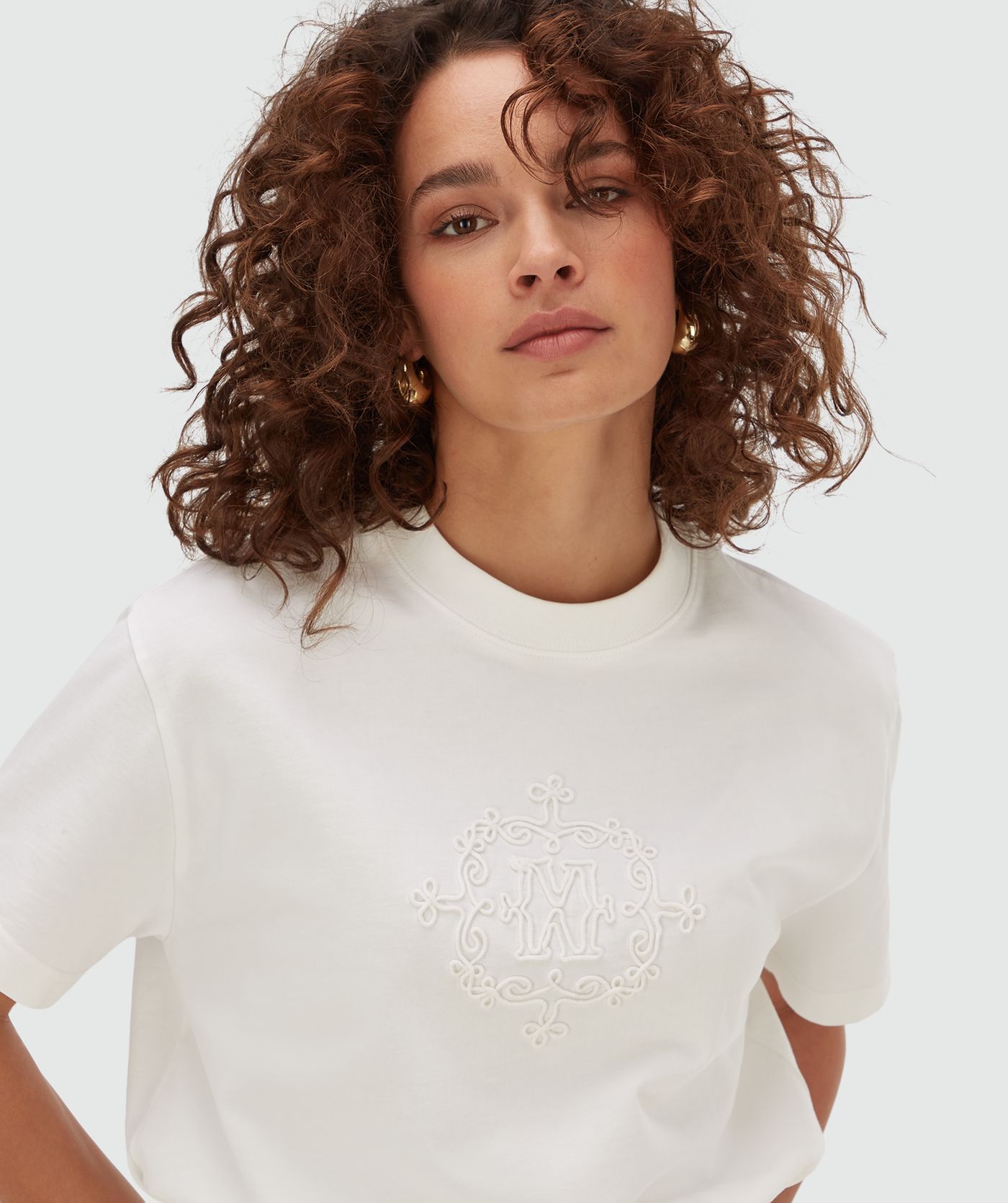Model draagt een oversized T-shirt met logo in de kleur off white met geborduurd JOSH V logo