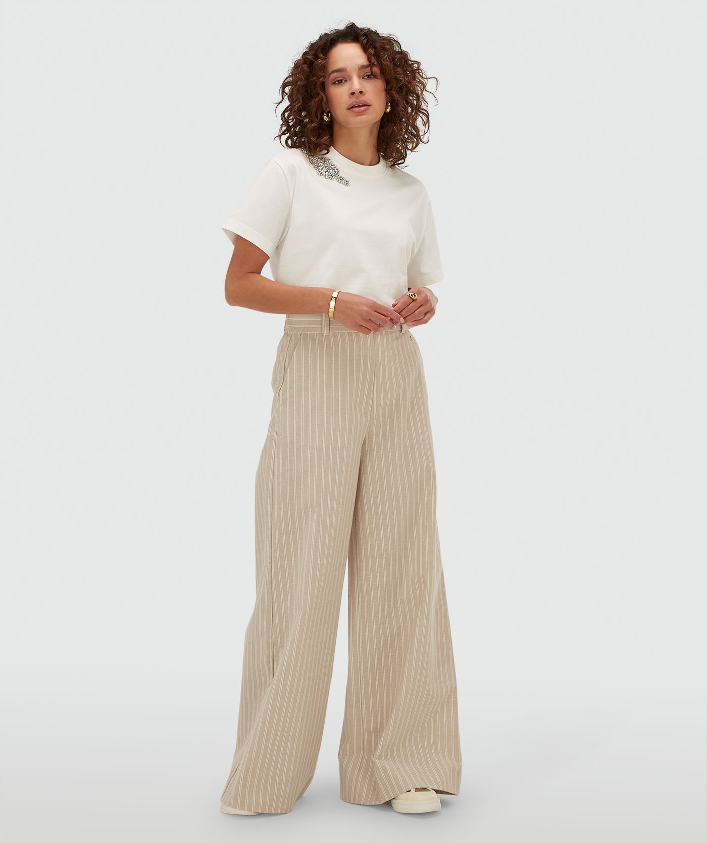 Model draagt een oversized T-shirt met strass in de kleur Off White