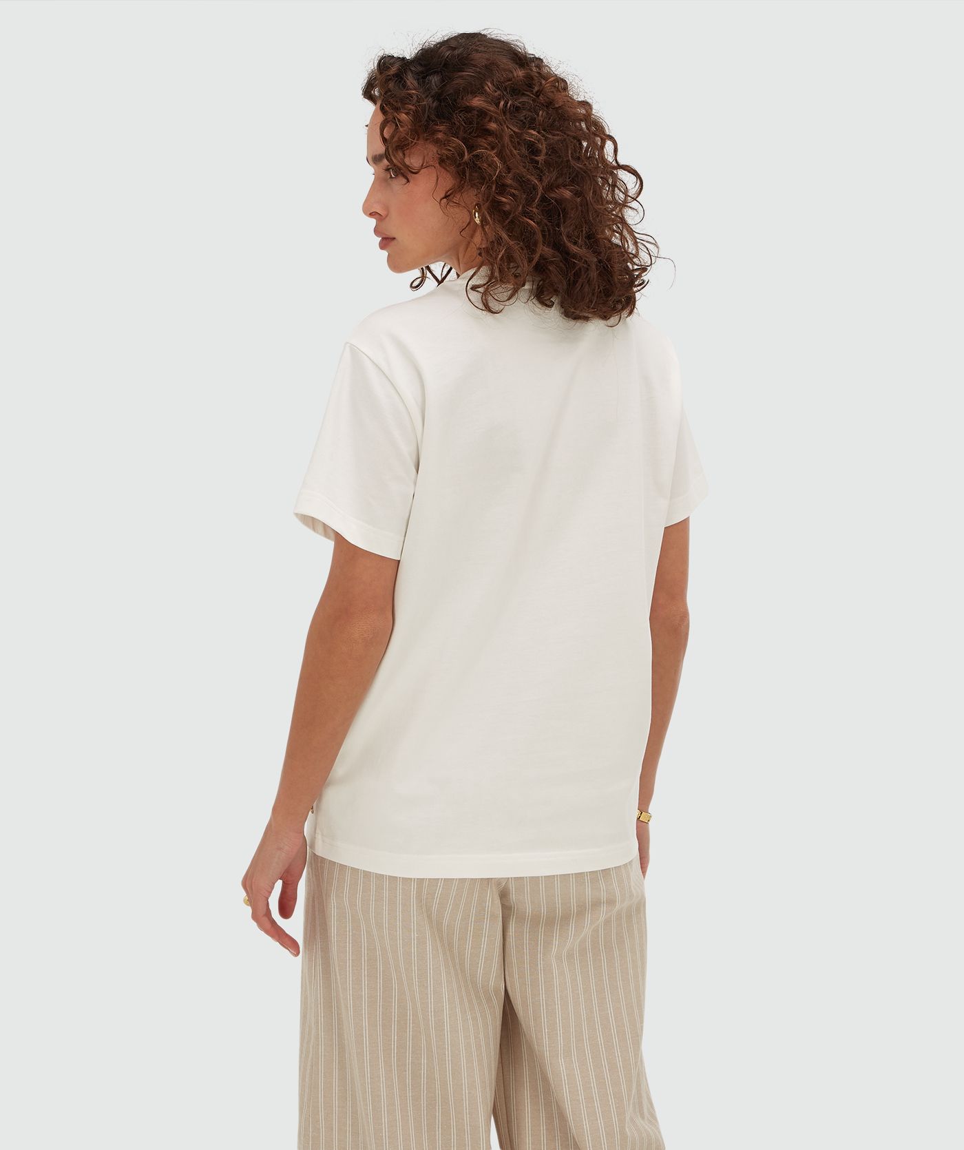 Achteraanzicht van een model in een oversized T-shirt met strass in de kleur Off White