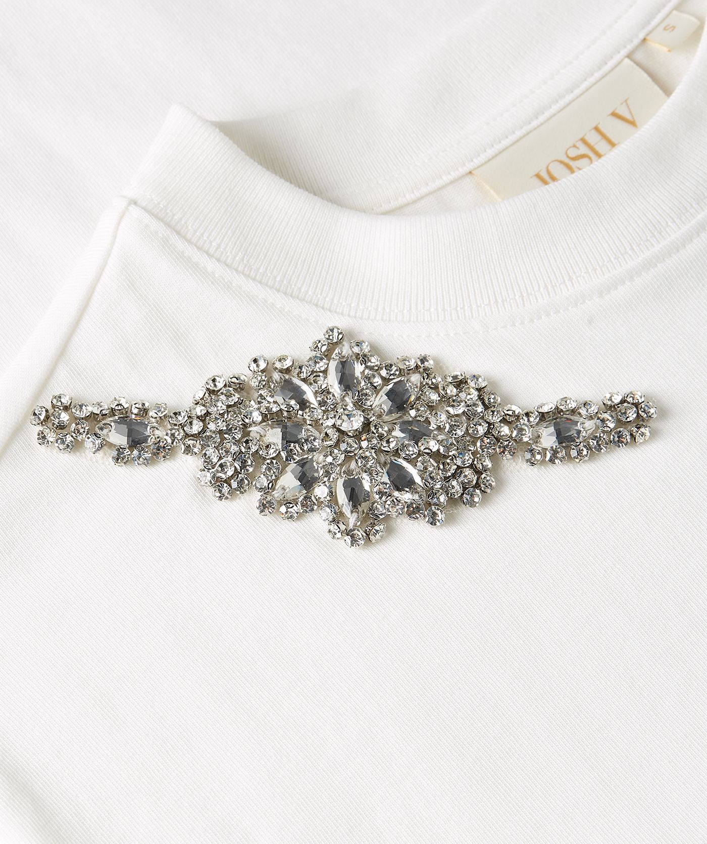 Close-up van een oversized T-shirt met strass in de kleur Off White