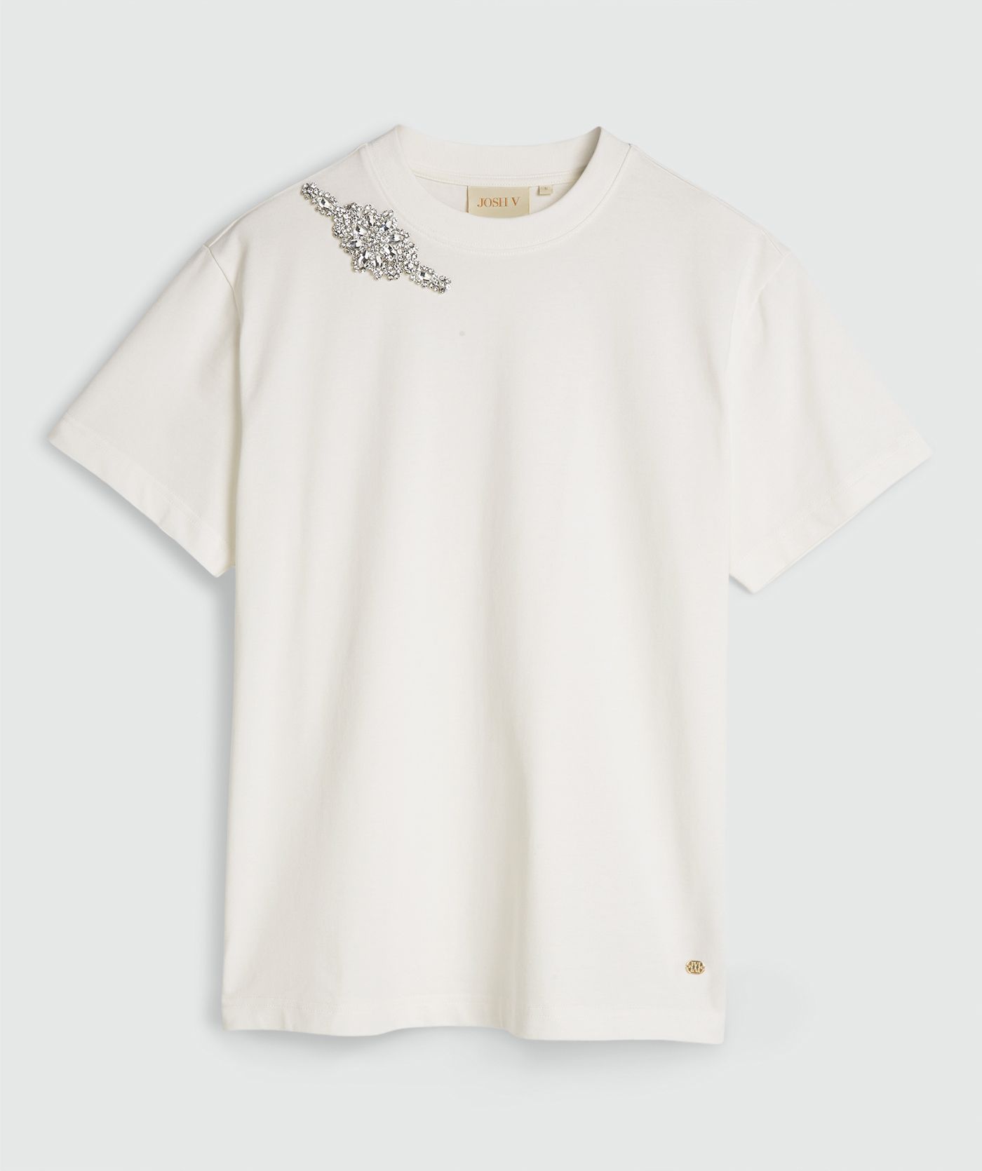 Een oversized T-shirt met strass in de kleur Off White, zonder model, weergegeven op een lichtgrijze achtergrond