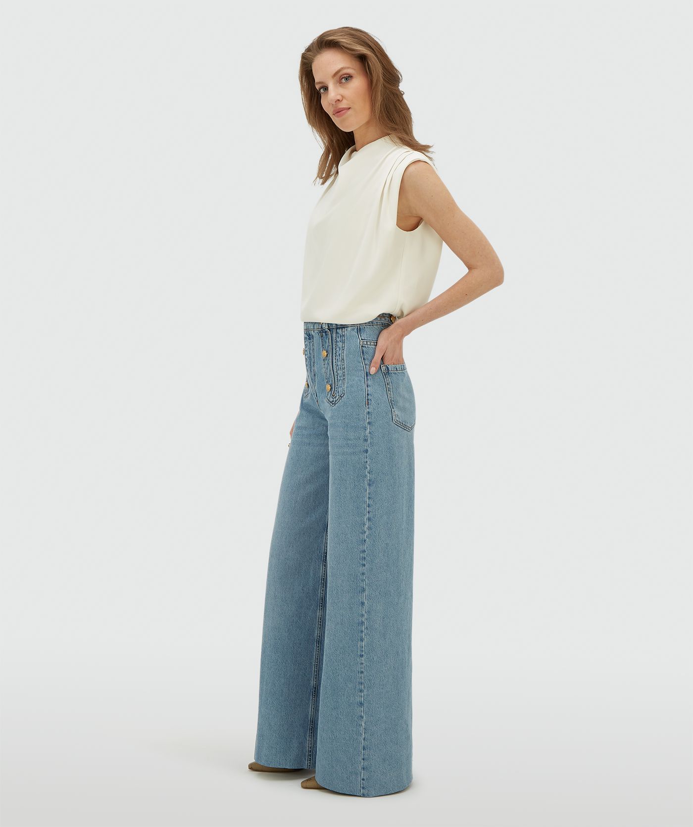 Model draagt een high waisted wide leg jeans in de kleur Light Blue Denim