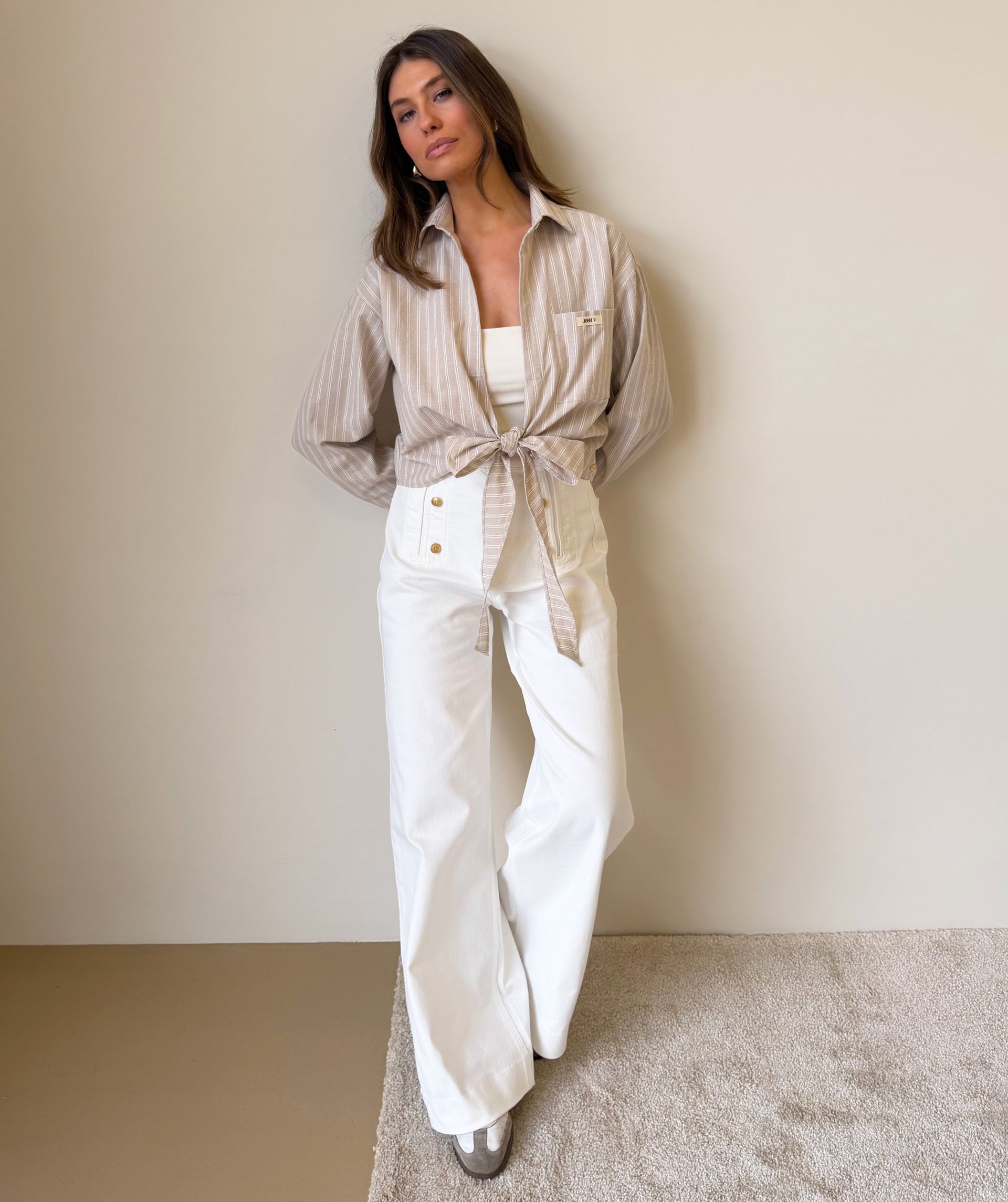 Model draagt een high waisted wide leg jeans in de kleur Light Ecru
