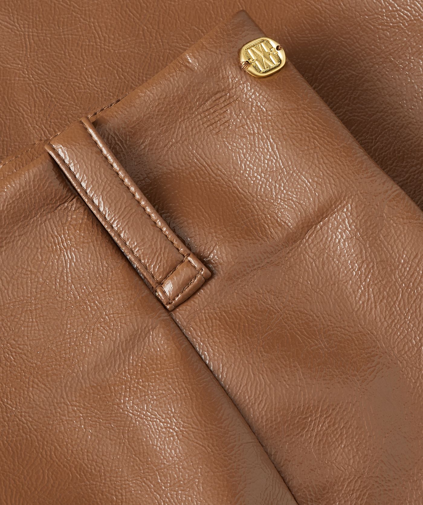 Close-up van de tailleband van de bruine lak look rok.