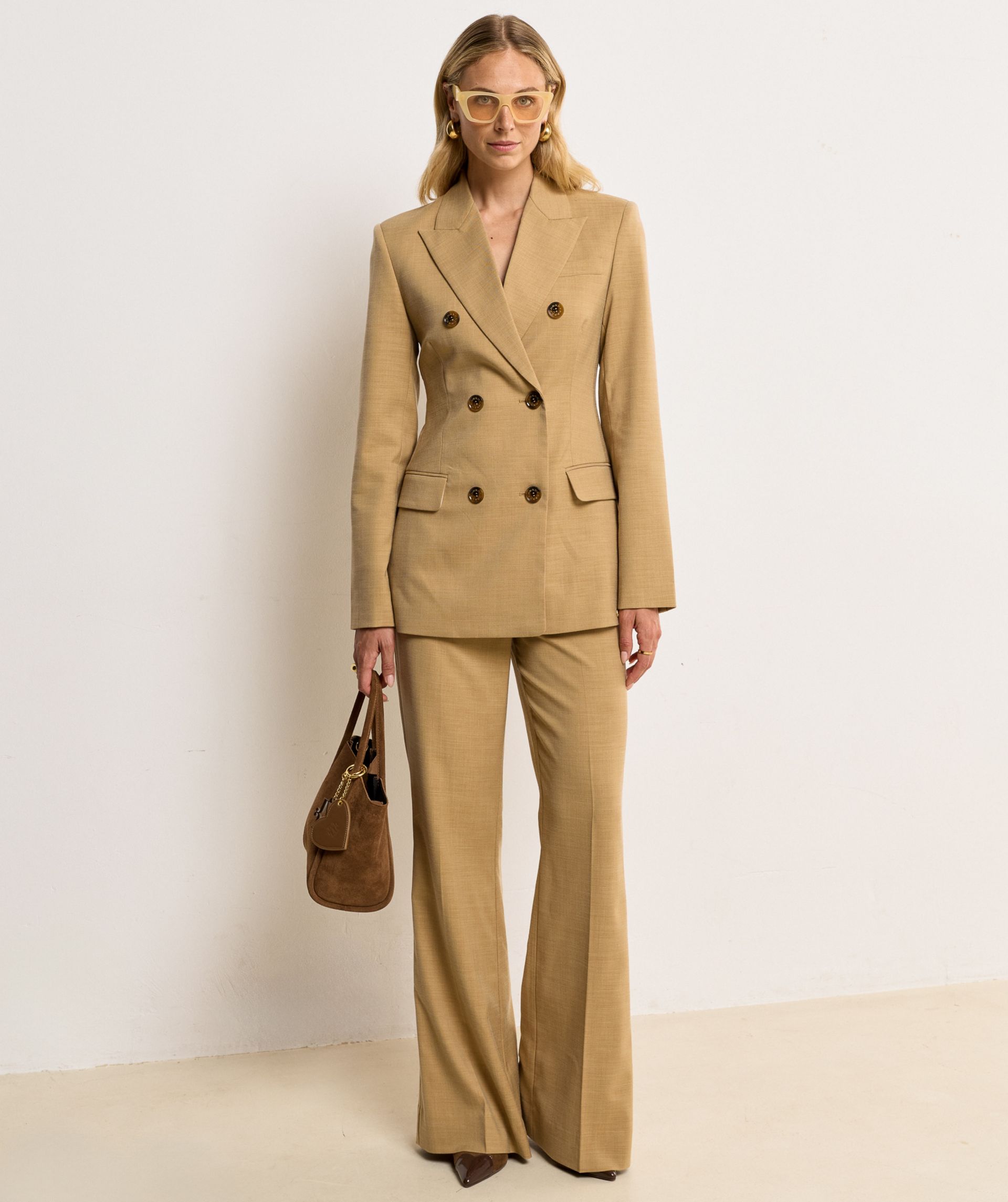 Model draagt een fitted blazer in de kleur Light Camel