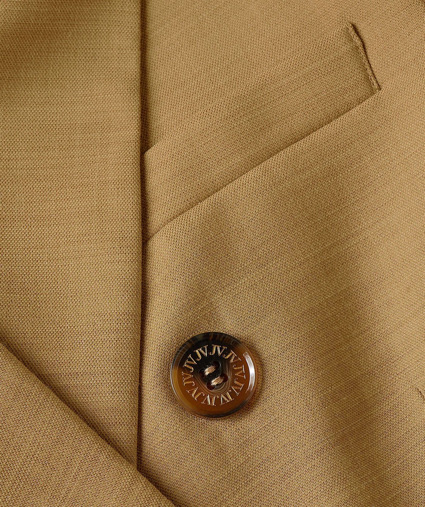 Close-up van een fitted blazer in de kleur Light Camel, waarbij de paspelzak op de borst aan de voorzijde zichtbaar is