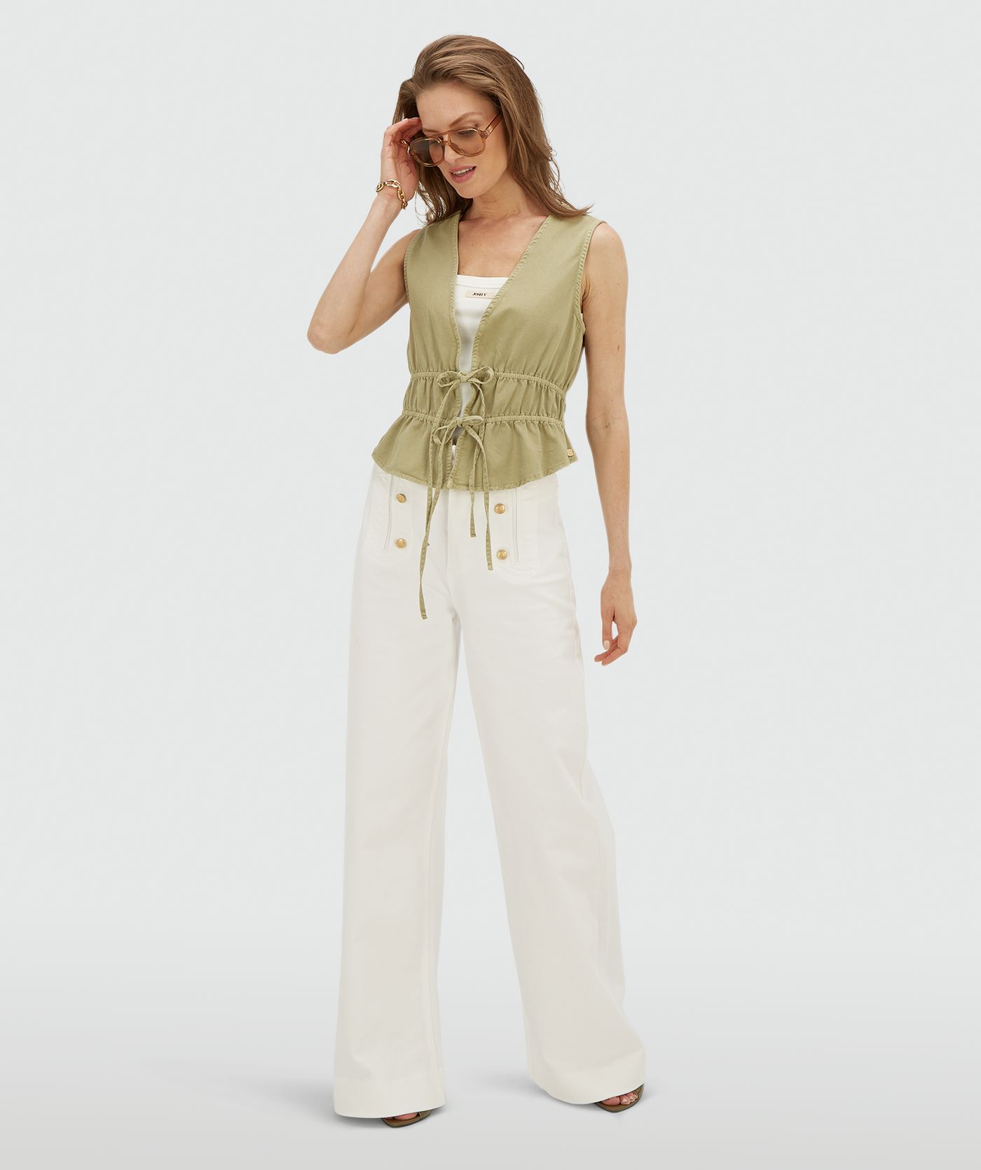 Model draagt een getailleerde top met peplum in de kleur Dark Pistachio