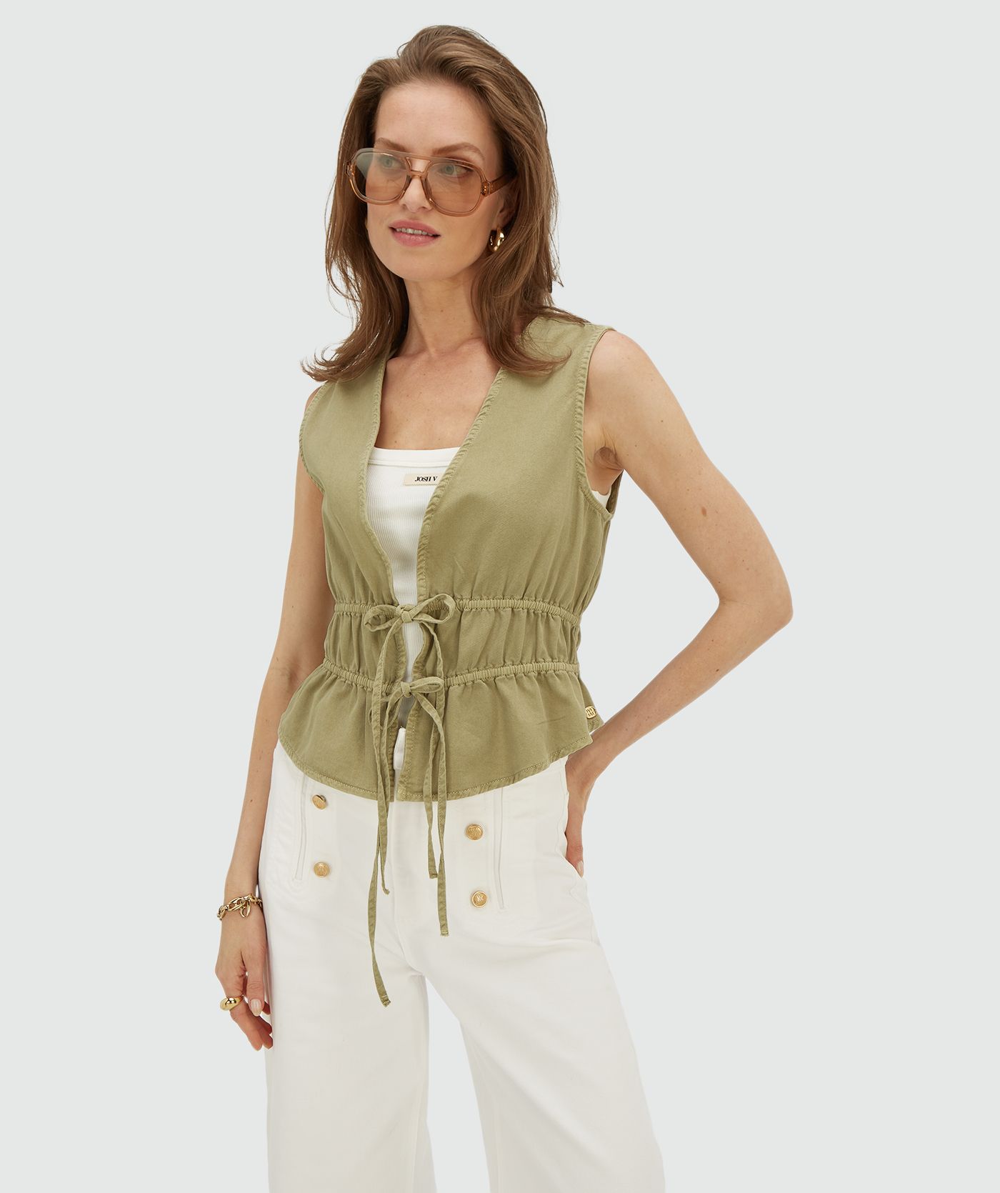 Model draagt een getailleerde top met peplum in de kleur Dark Pistachio