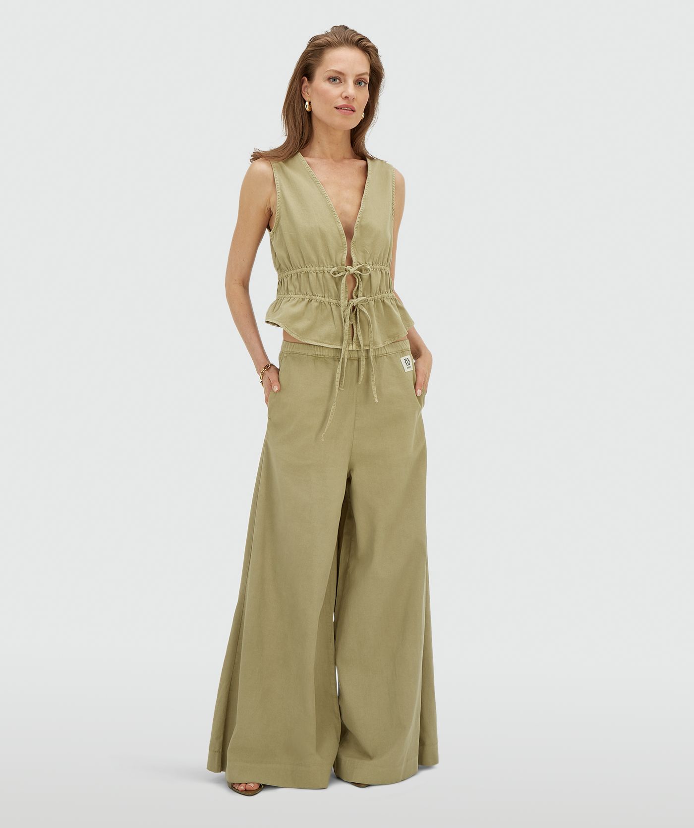 Model draagt een getailleerde top met peplum in de kleur Dark Pistachio