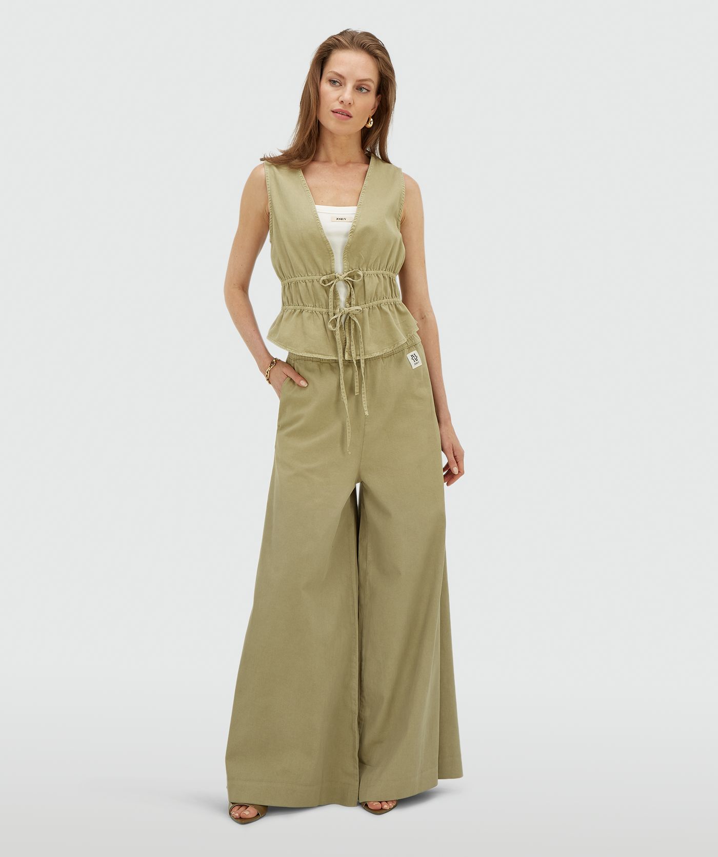 Model draagt een getailleerde top met peplum in de kleur Dark Pistachio