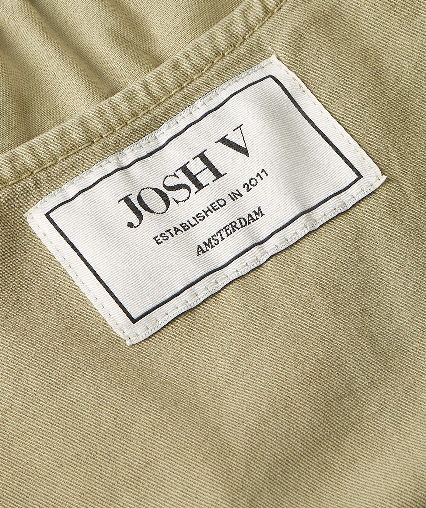Close-up van een getailleerde top met peplum in de kleur Dark Pistachio