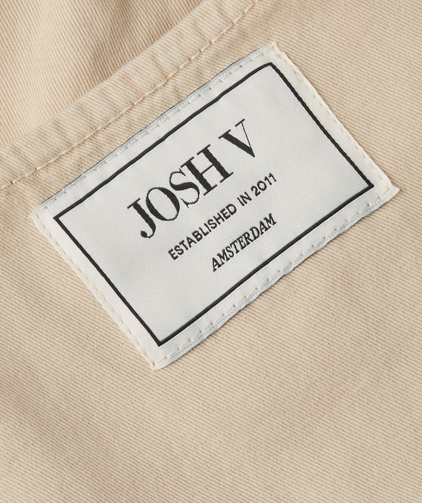 Close-up van een getailleerde top met peplum, in de kleur Oat