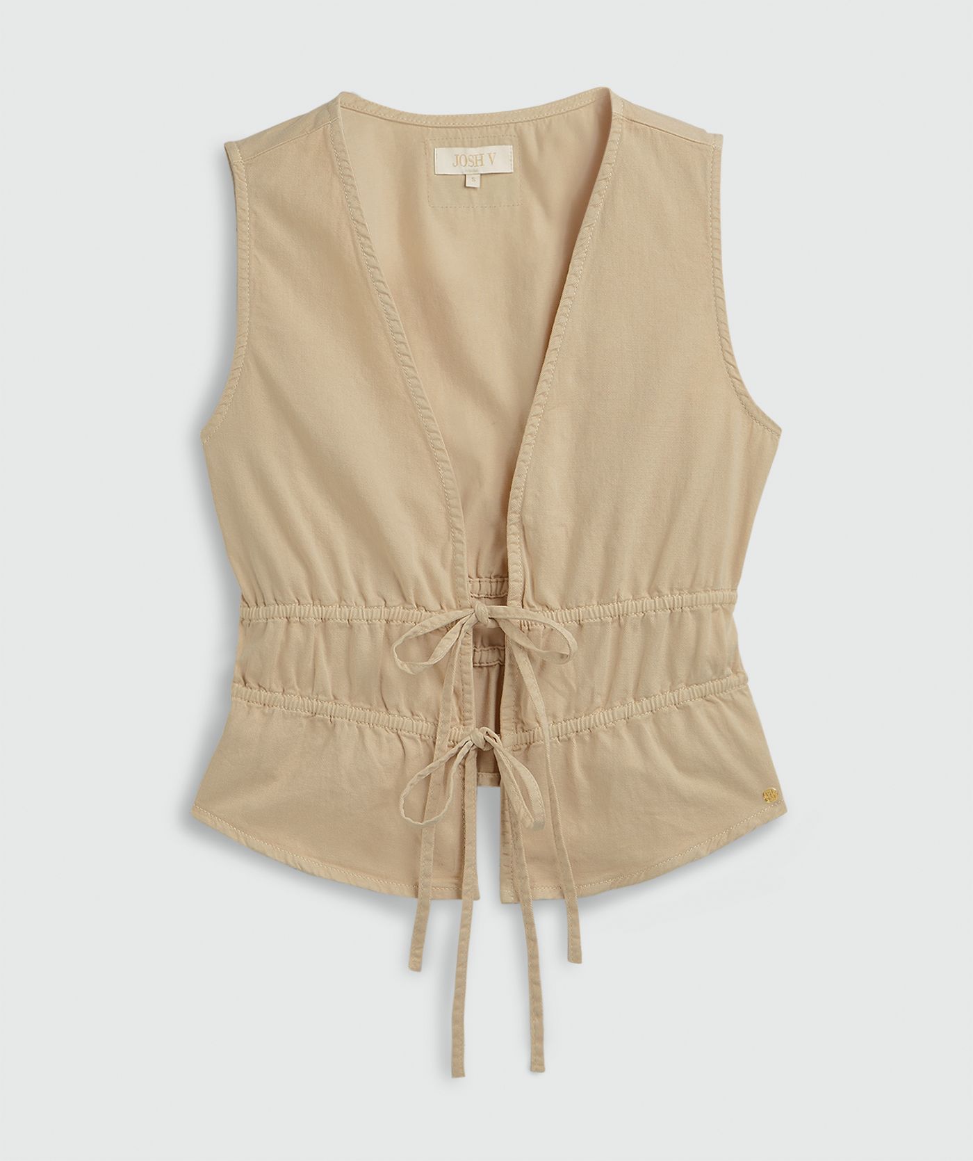 Een getailleerde top met peplum, in de kleur Oat, weergegeven op een lichtgrijze achtergrond