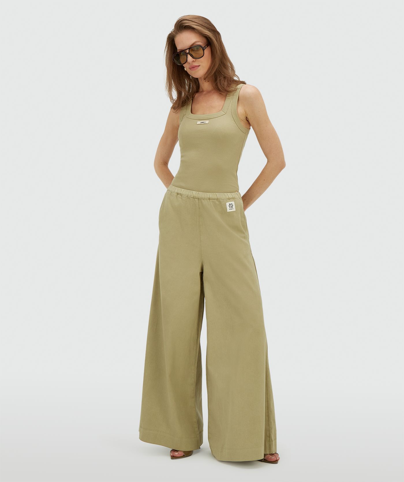 Model draagt een wide leg pantalon in de kleur Dark Pistachio