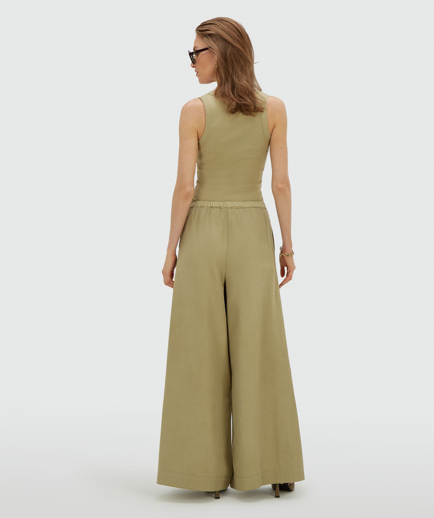 Achteraanzicht van een model in een wide leg pantalon in de kleur Dark Pistachio