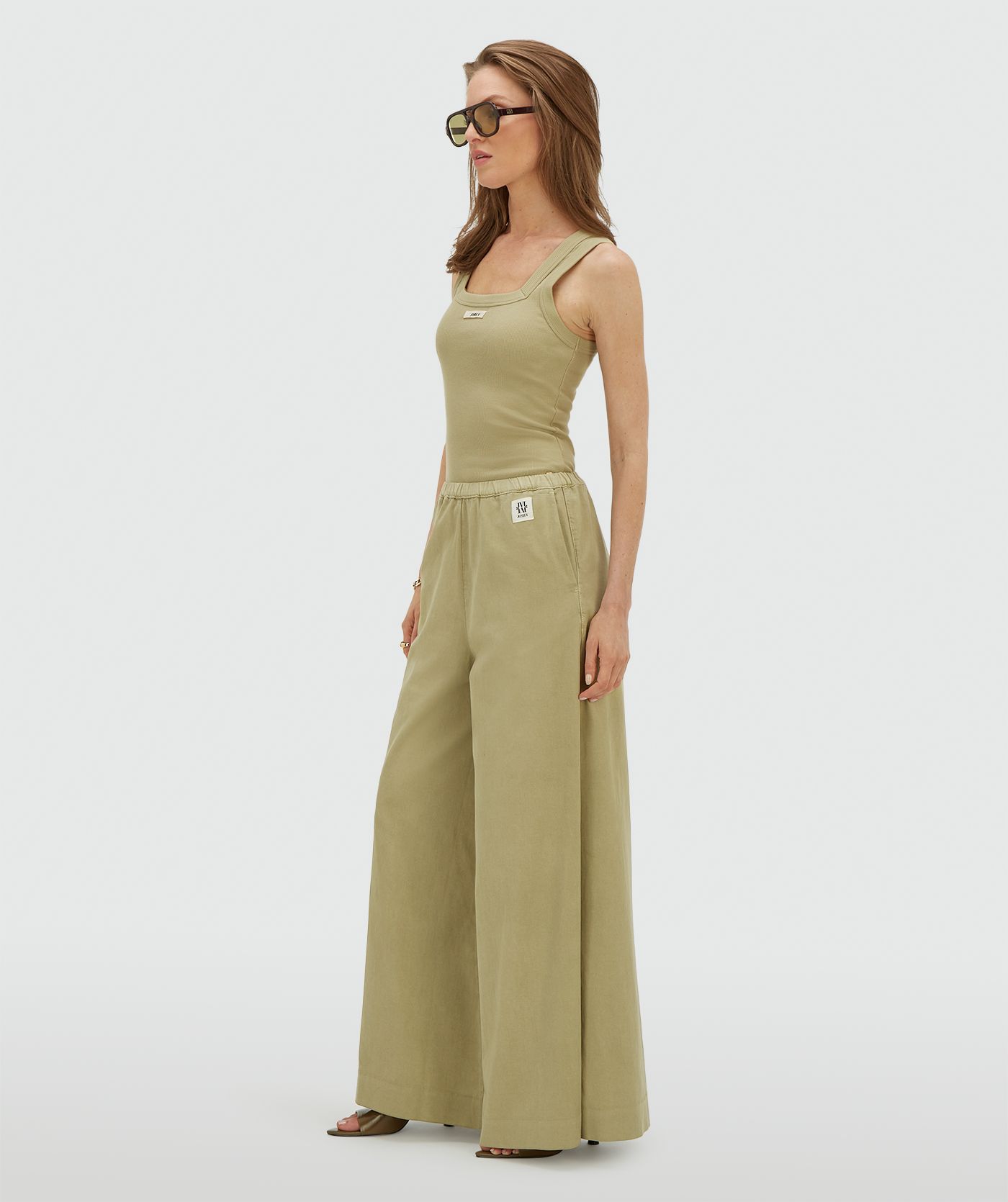 Model draagt een wide leg pantalon in de kleur Dark Pistachio