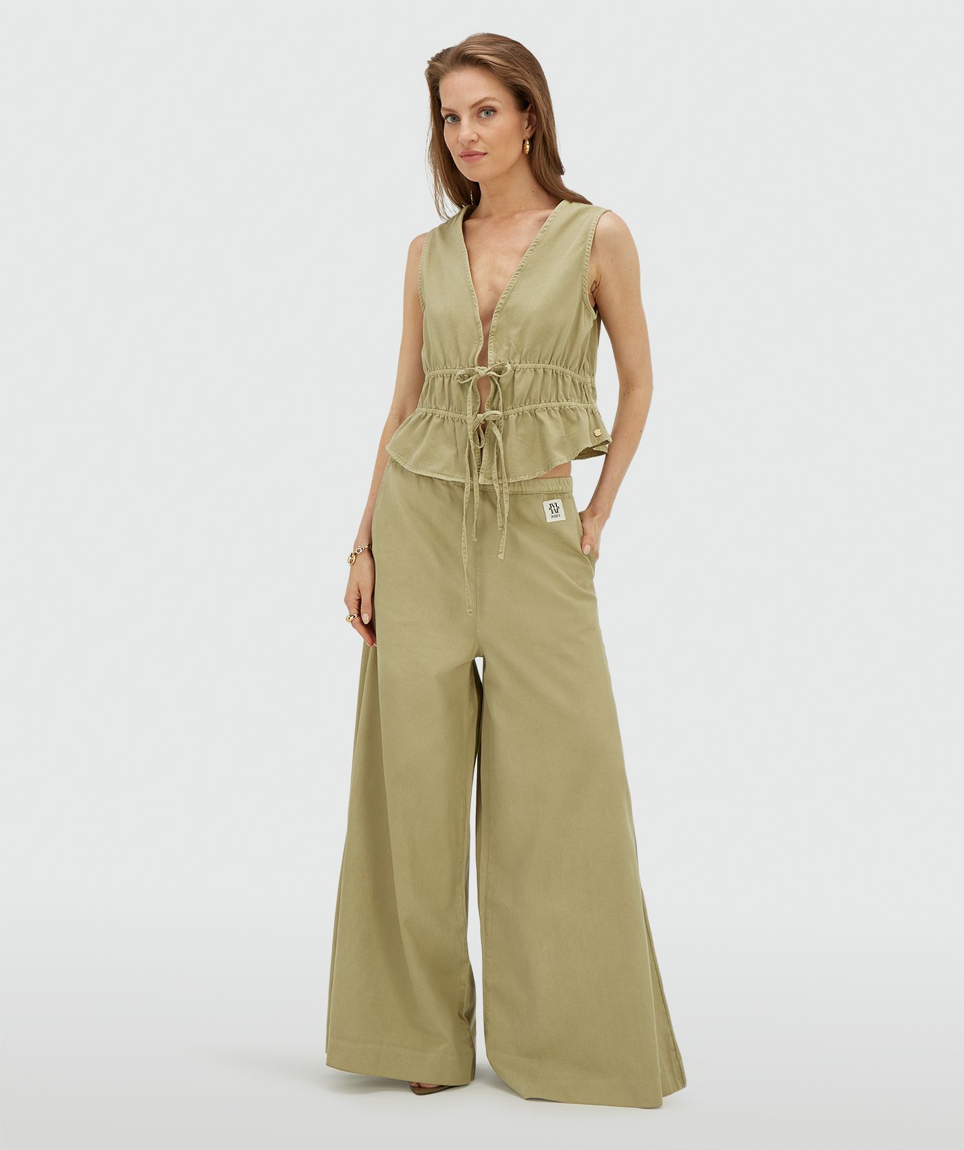Model draagt een wide leg pantalon in de kleur Dark Pistachio