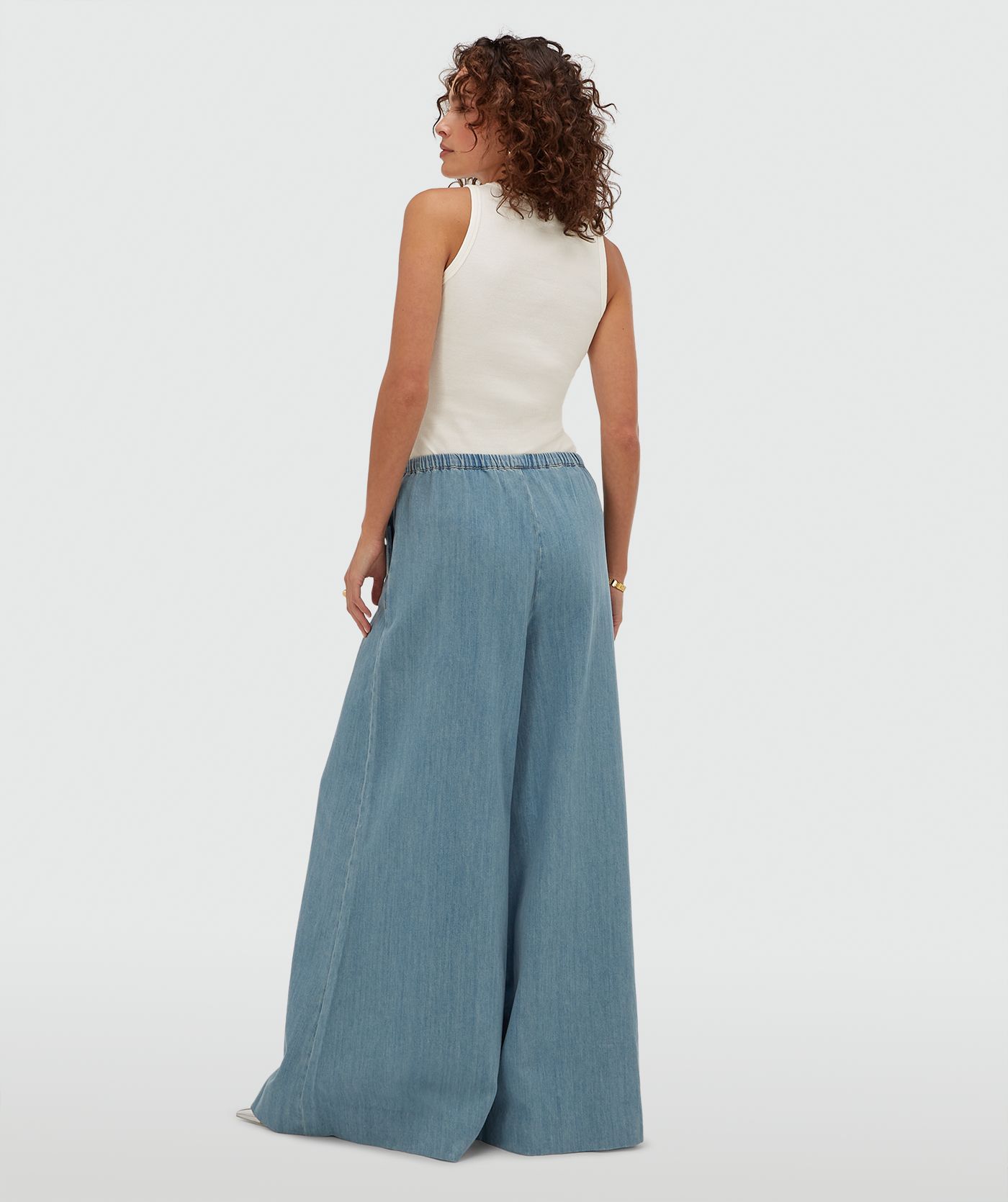 Achteraanzicht van een model in een wide leg pantalon in denim look