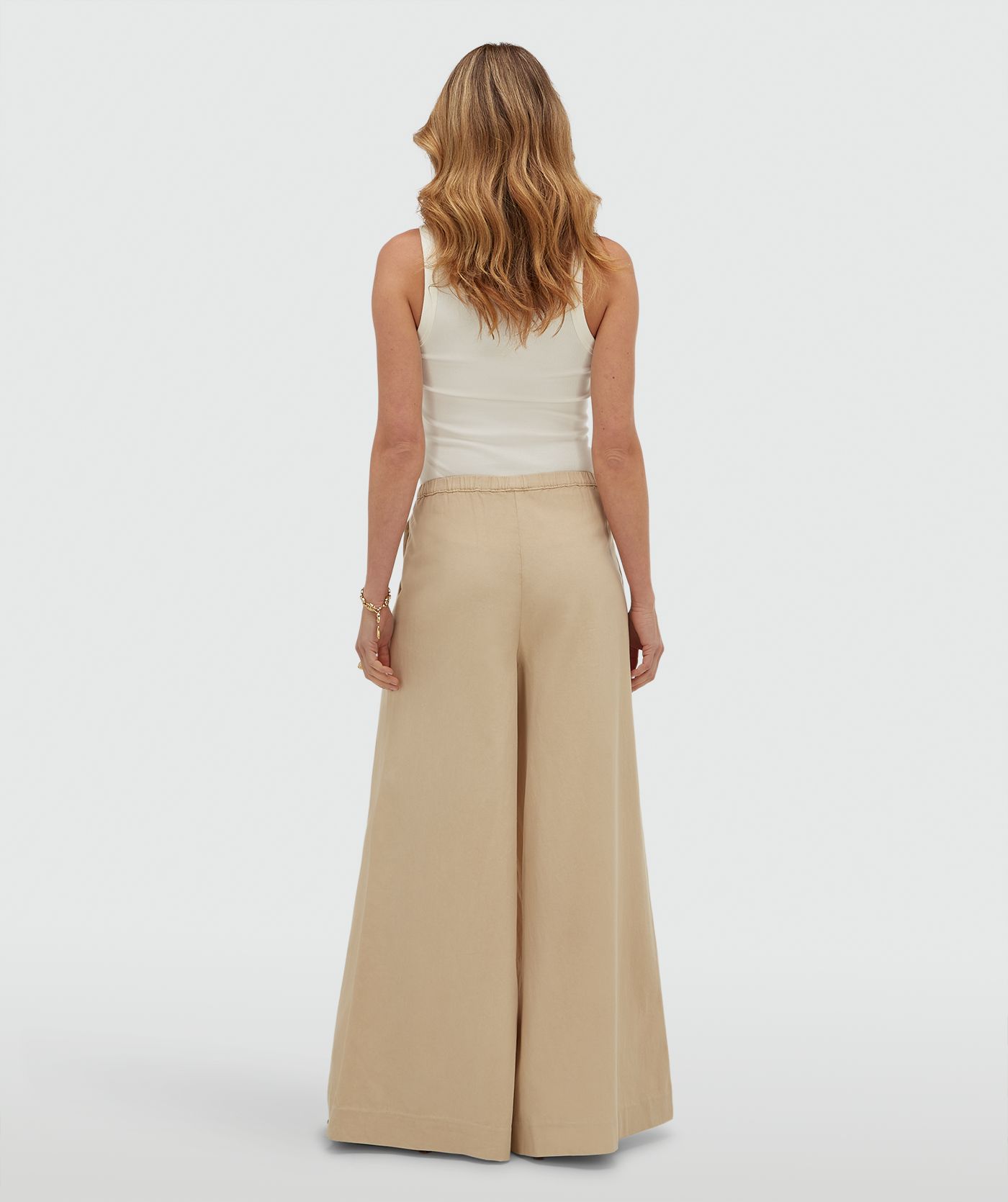 Achteraanzicht van een model in een wide leg pantalon, in de kleur Oat
