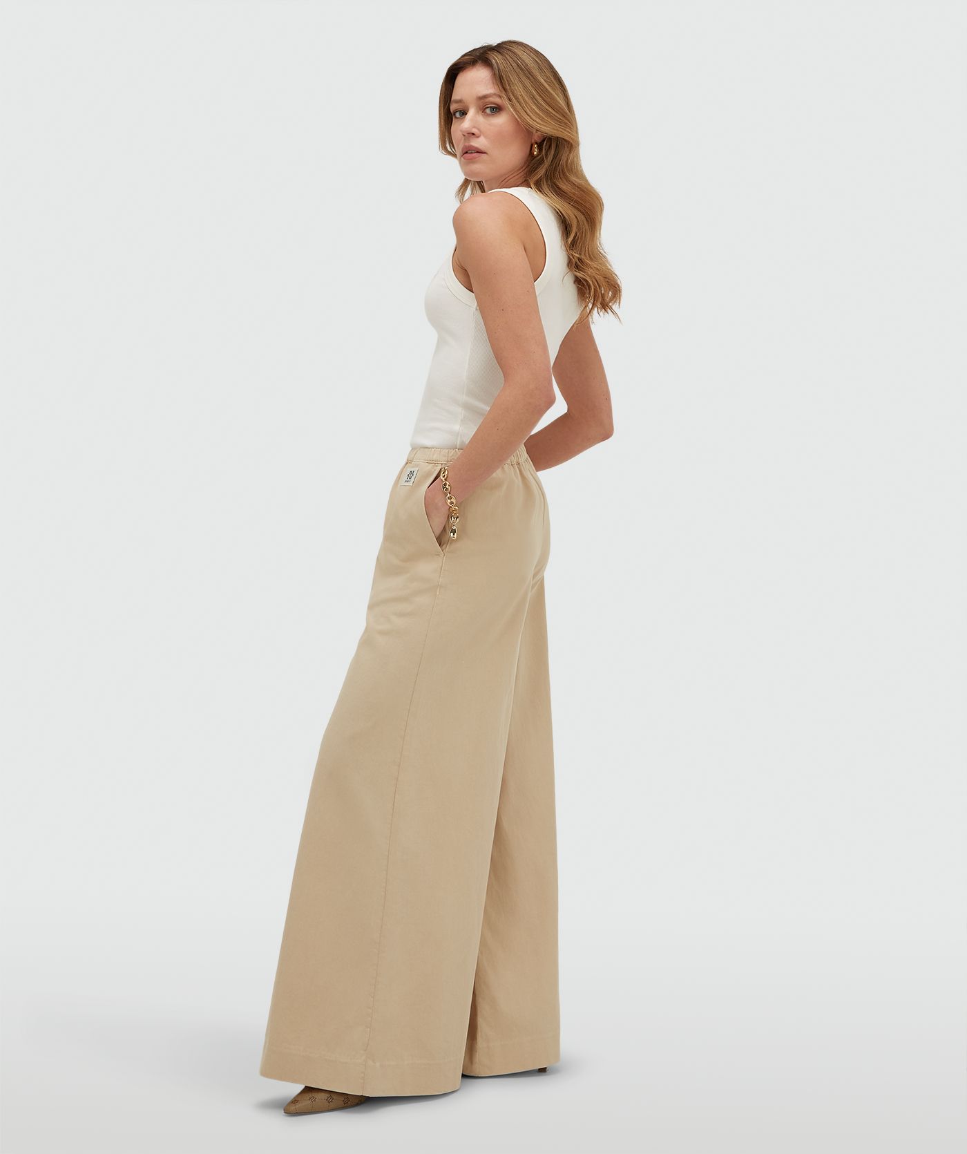 Zijaanzicht van een model in een wide leg pantalon, in de kleur Oat