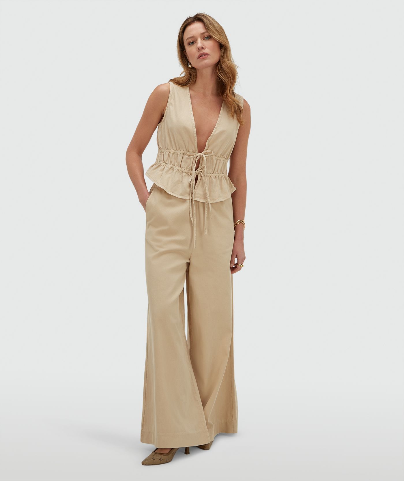 Model draagt een wide leg pantalon, in de kleur Oat