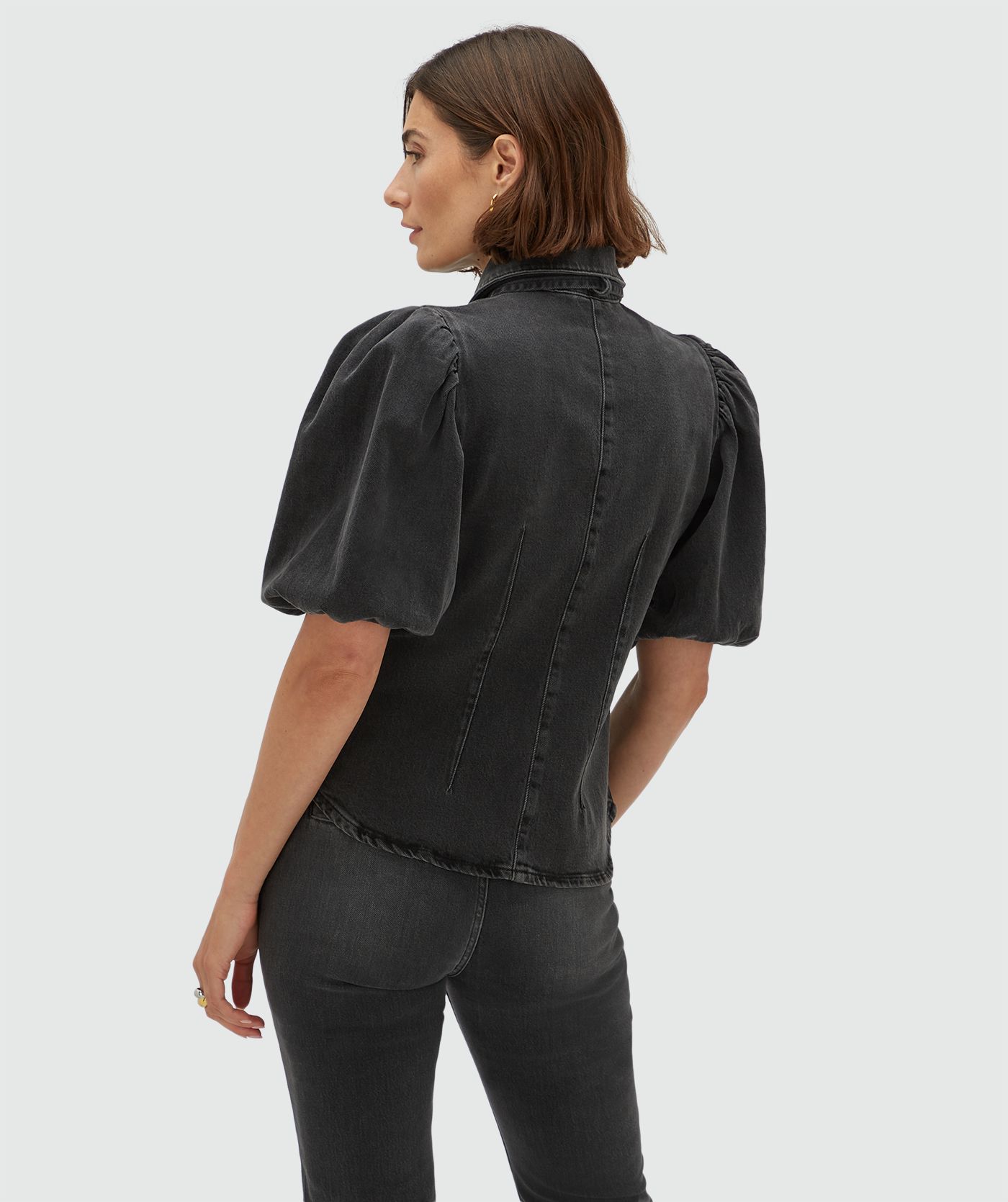 Achteraanzicht van een model in een regular fit denim blouse met strikdetail