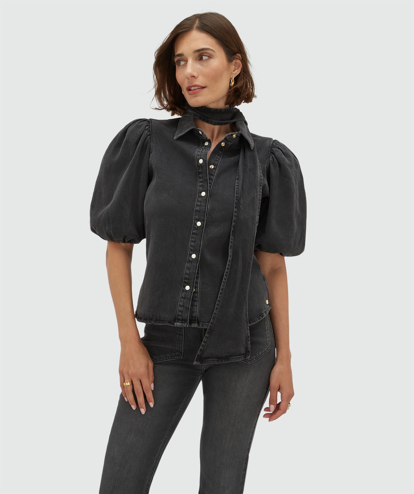 Model draagt een regular fit denim blouse met strikdetail