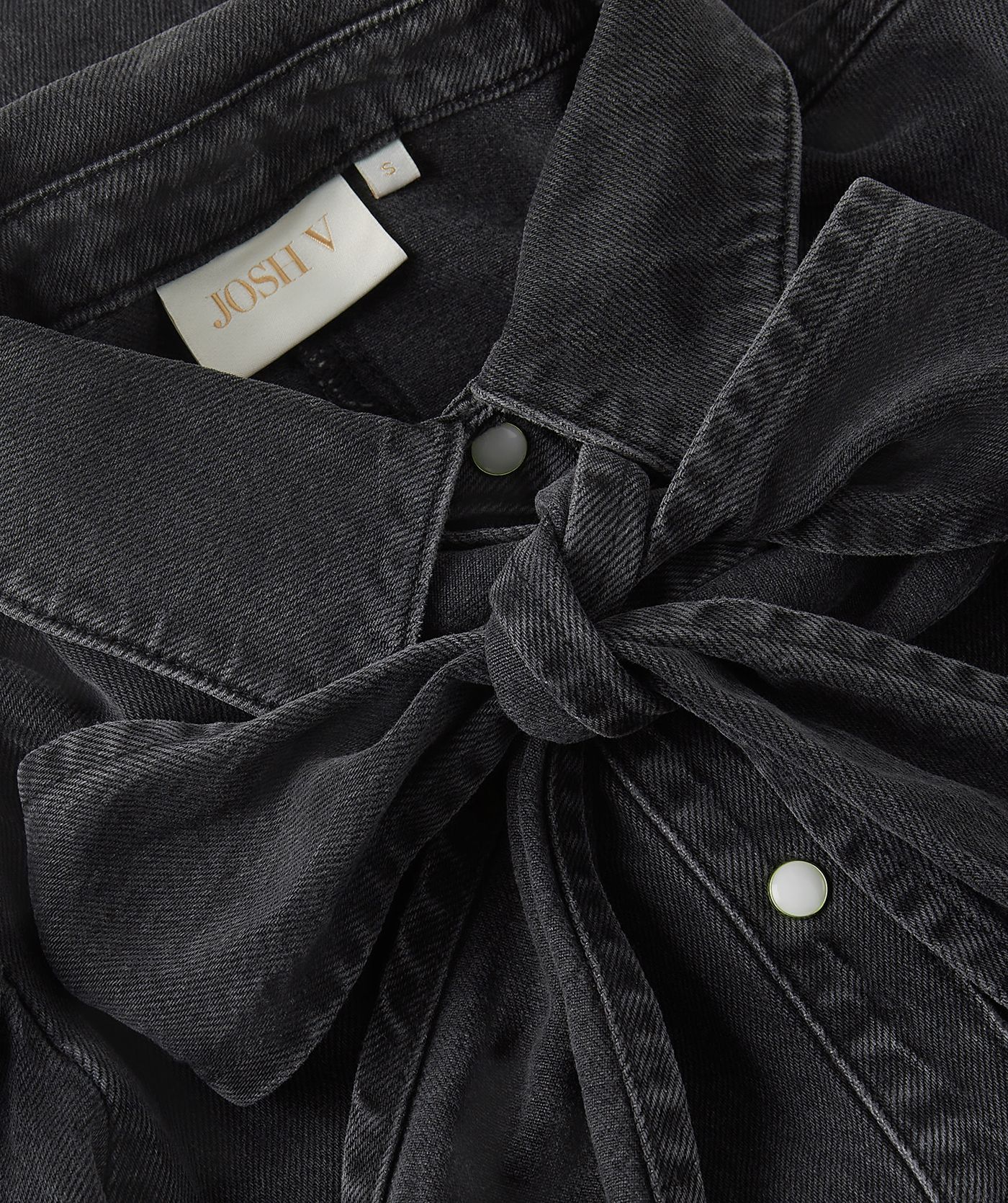 Close-up van een regular fit denim blouse met strikdetail