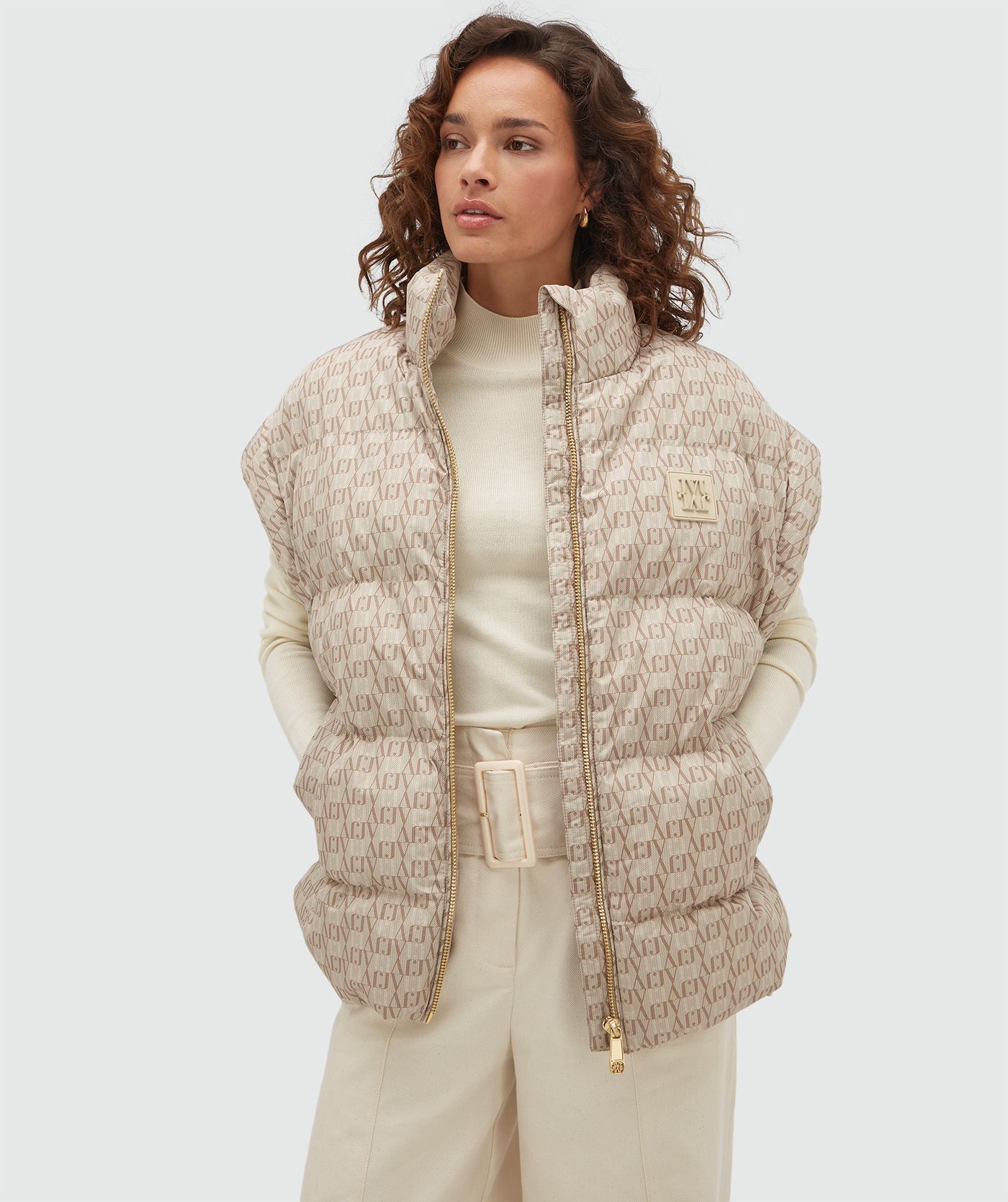 Model draagt een bodywarmer met een overall JOSH V-logo print in de kleur beige.