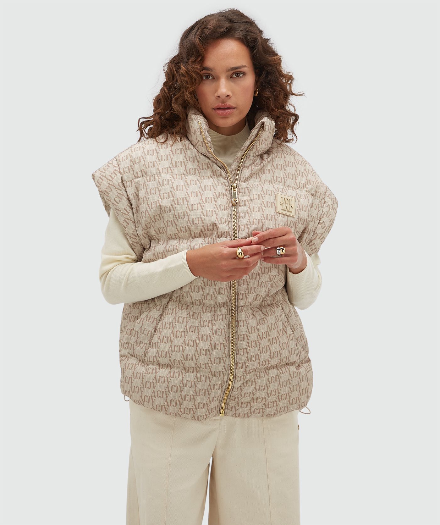 Model draagt een bodywarmer met een overall JOSH V-logo print in de kleur beige.
