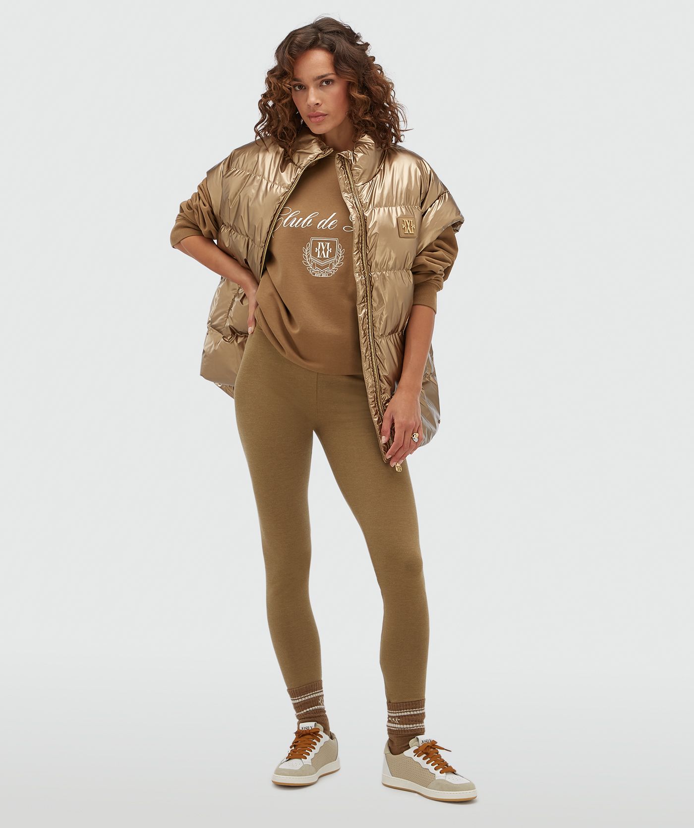 Model draagt een oversized metallic look bodywarmer in de kleur bruin.