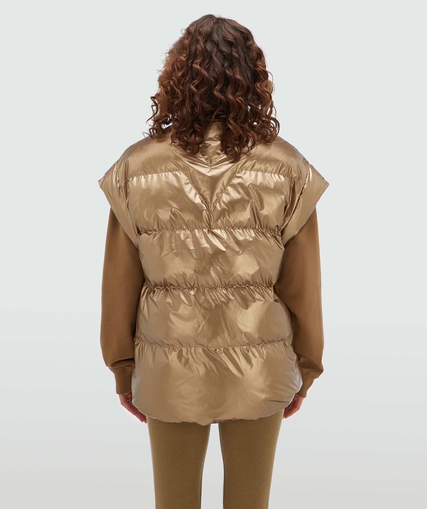 Achteraanzicht van een model in een oversized bodywarmer in een metallic look.