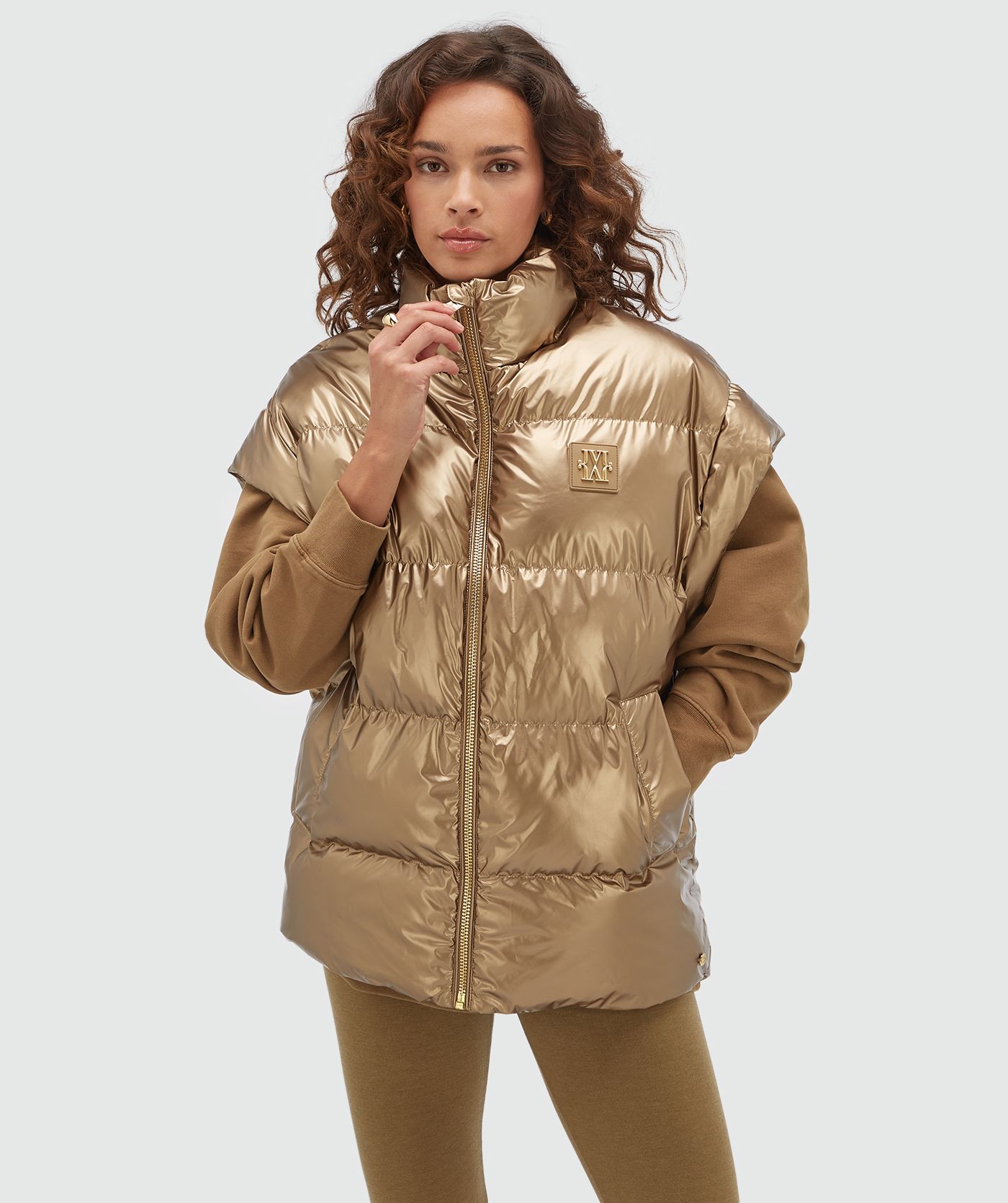 Model draagt een oversized metallic look bodywarmer in de kleur bruin.