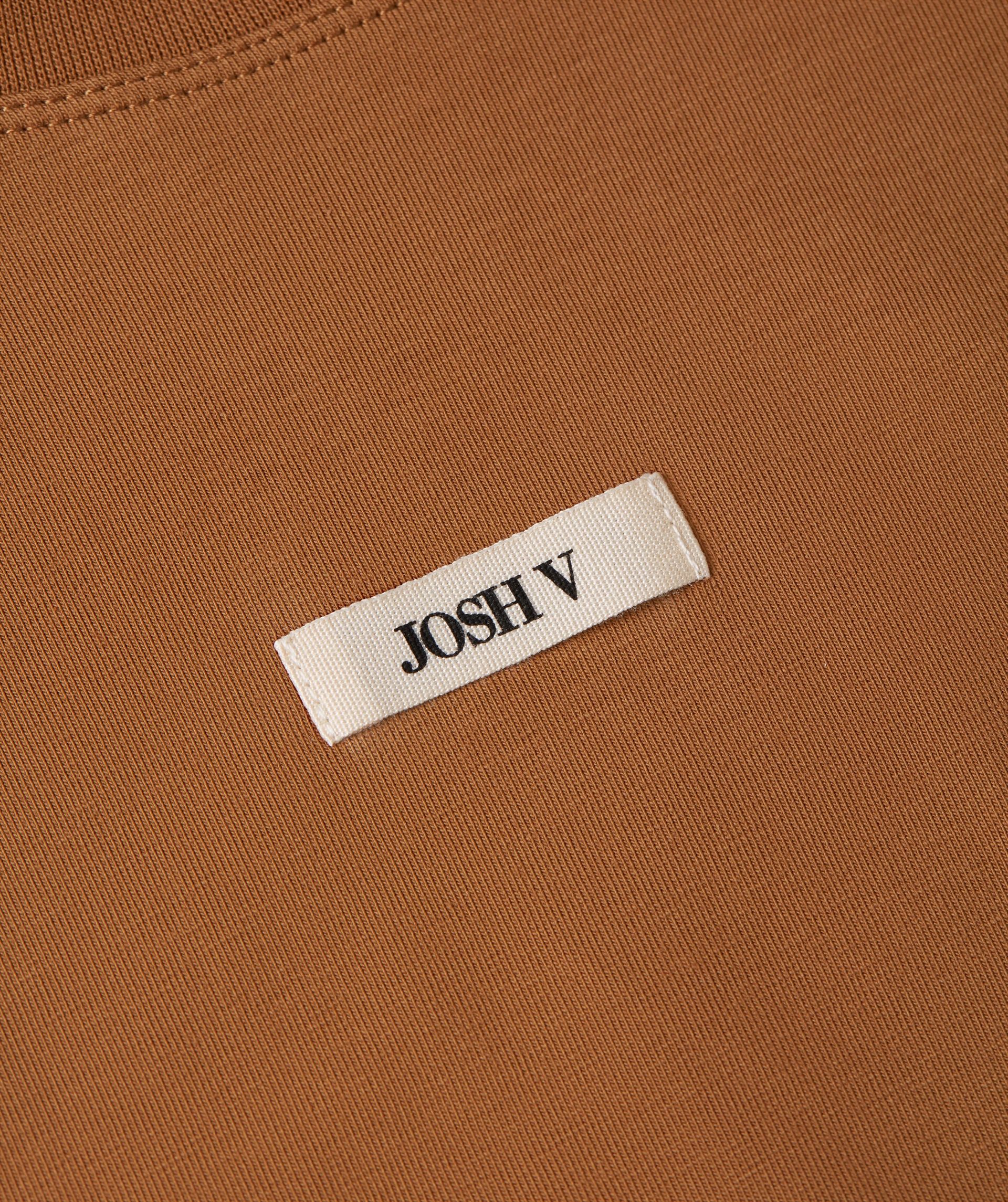 Close-up van Josh v logo op de borst.