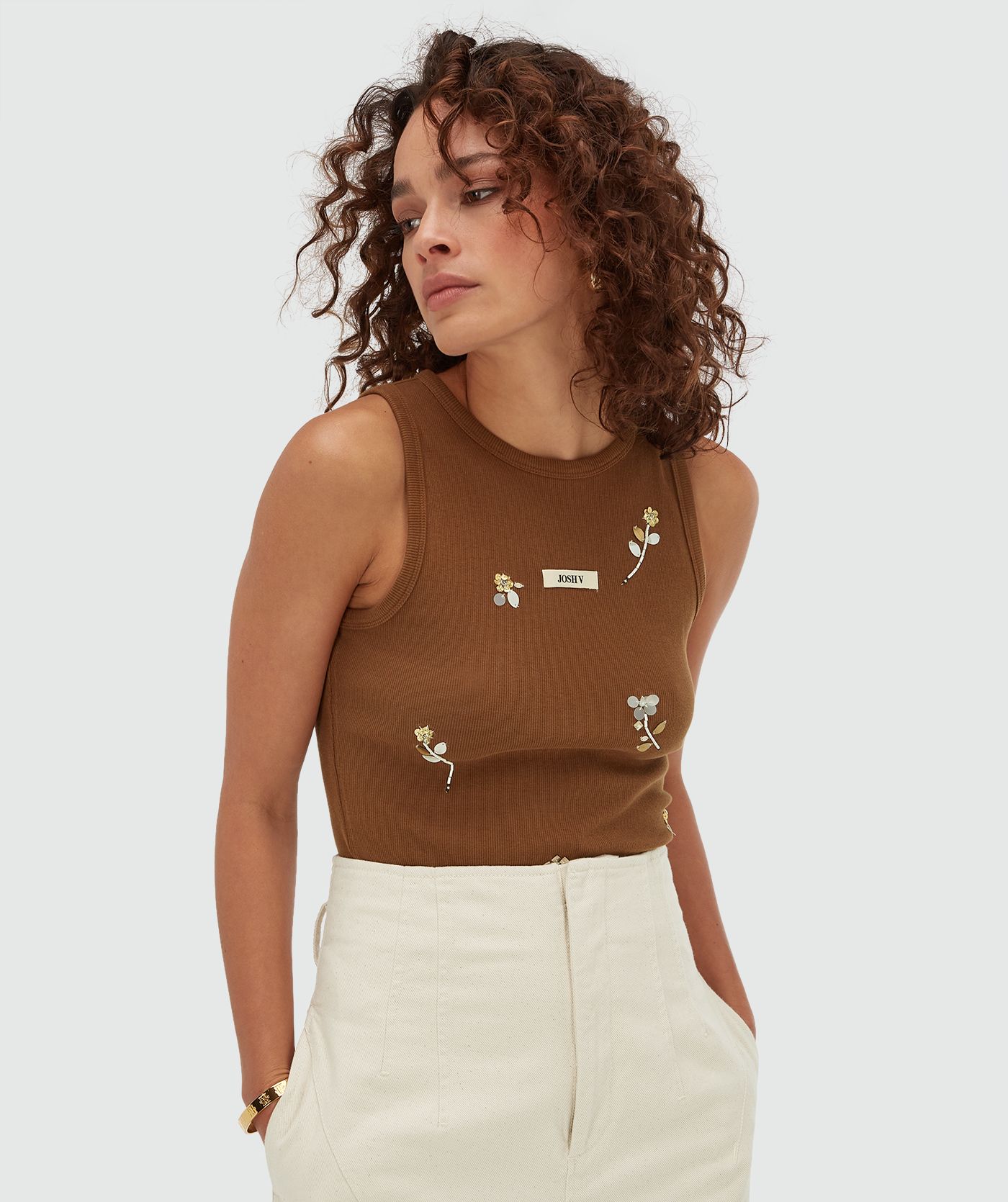 Model draagt een slim fit top met kralen details in de kleur Brown