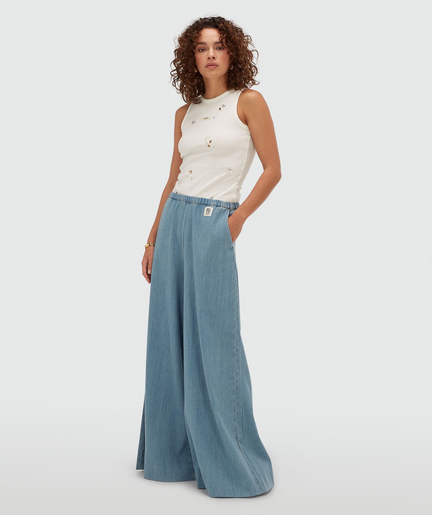 Model draagt een slim fit top met kralen details in de kleur Off White