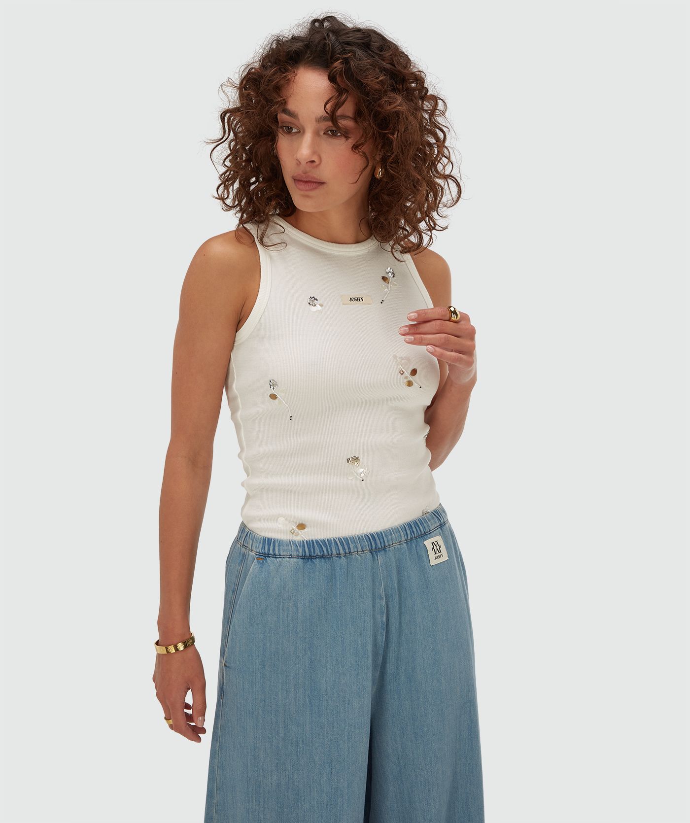 Model draagt een slim fit top met kralen details in de kleur Off White