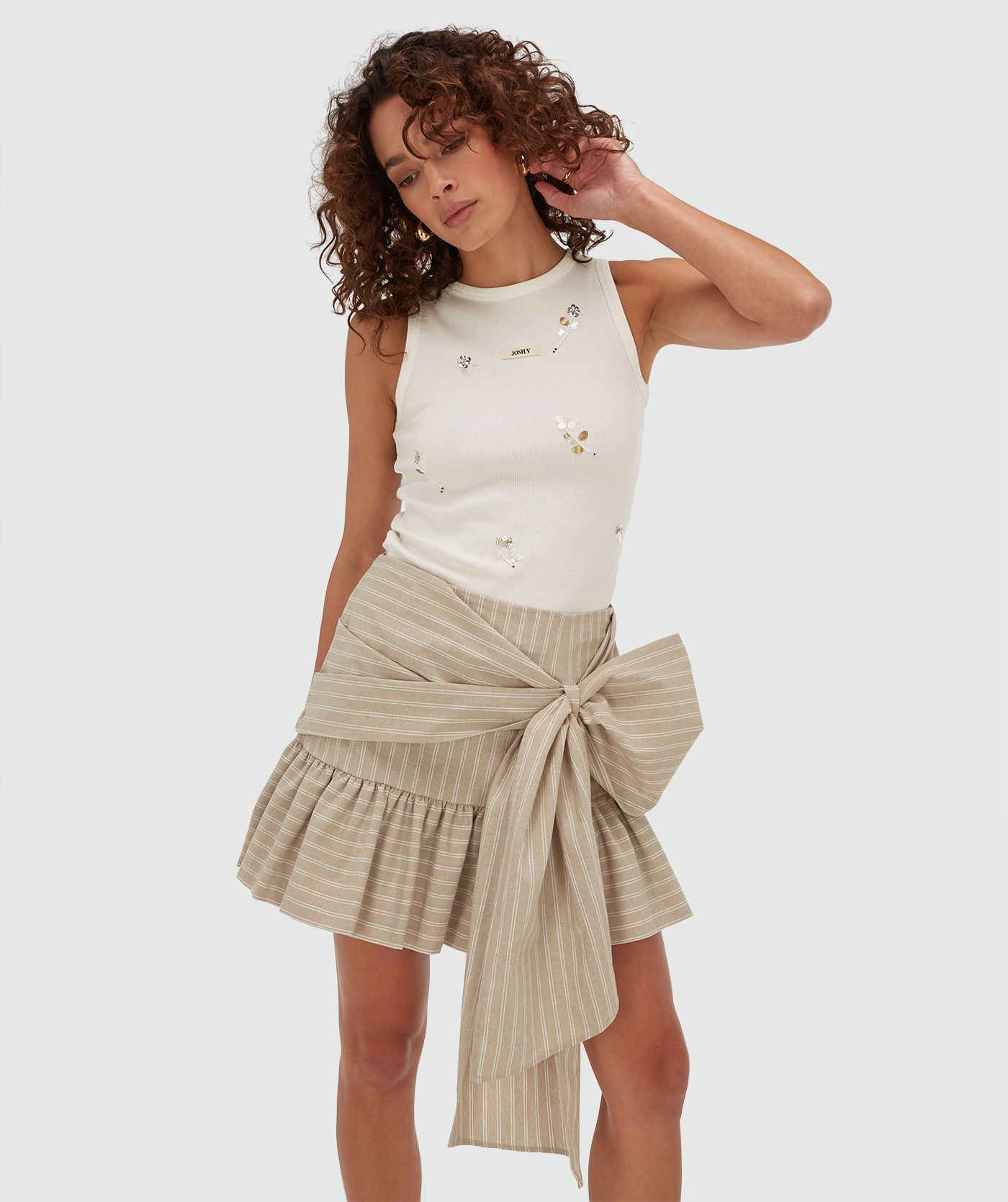 Model draagt een slim fit top met kralen details in de kleur Off White
