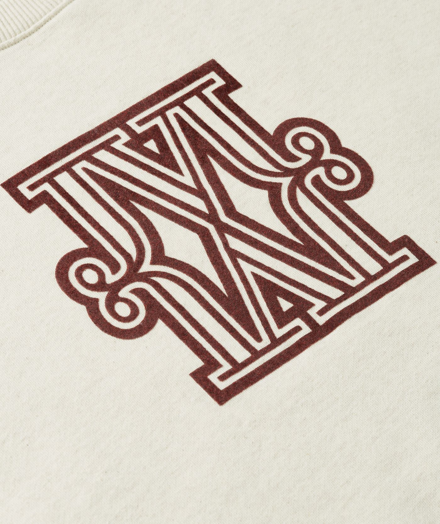 Close-up van donkerrood JOSH V logo dat op de voorkant zit van de sweater.