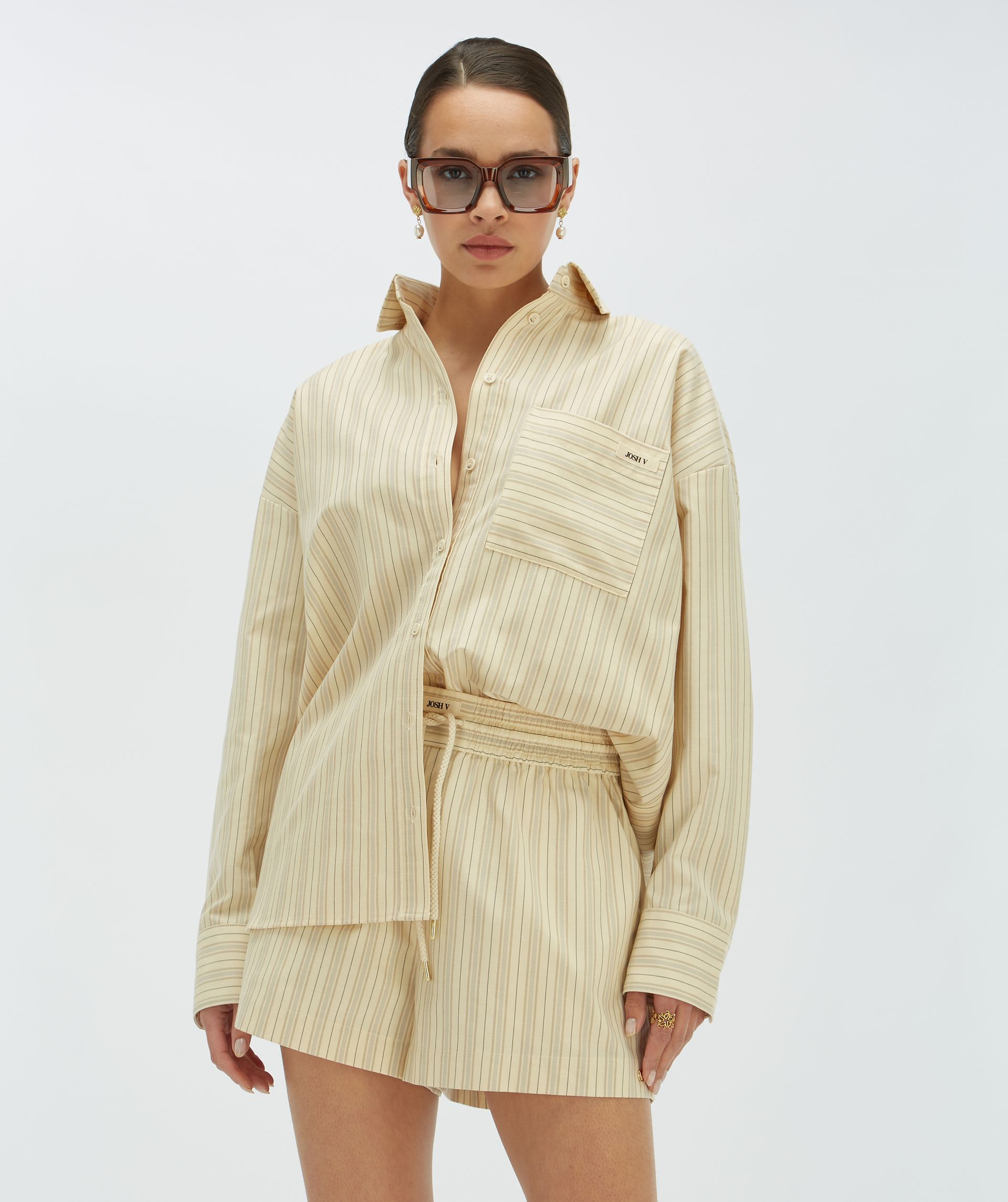 Model draagt een regular fit kort broekje met strepen, gecombineerd met bijpassende Lova blouse - Josh V.
